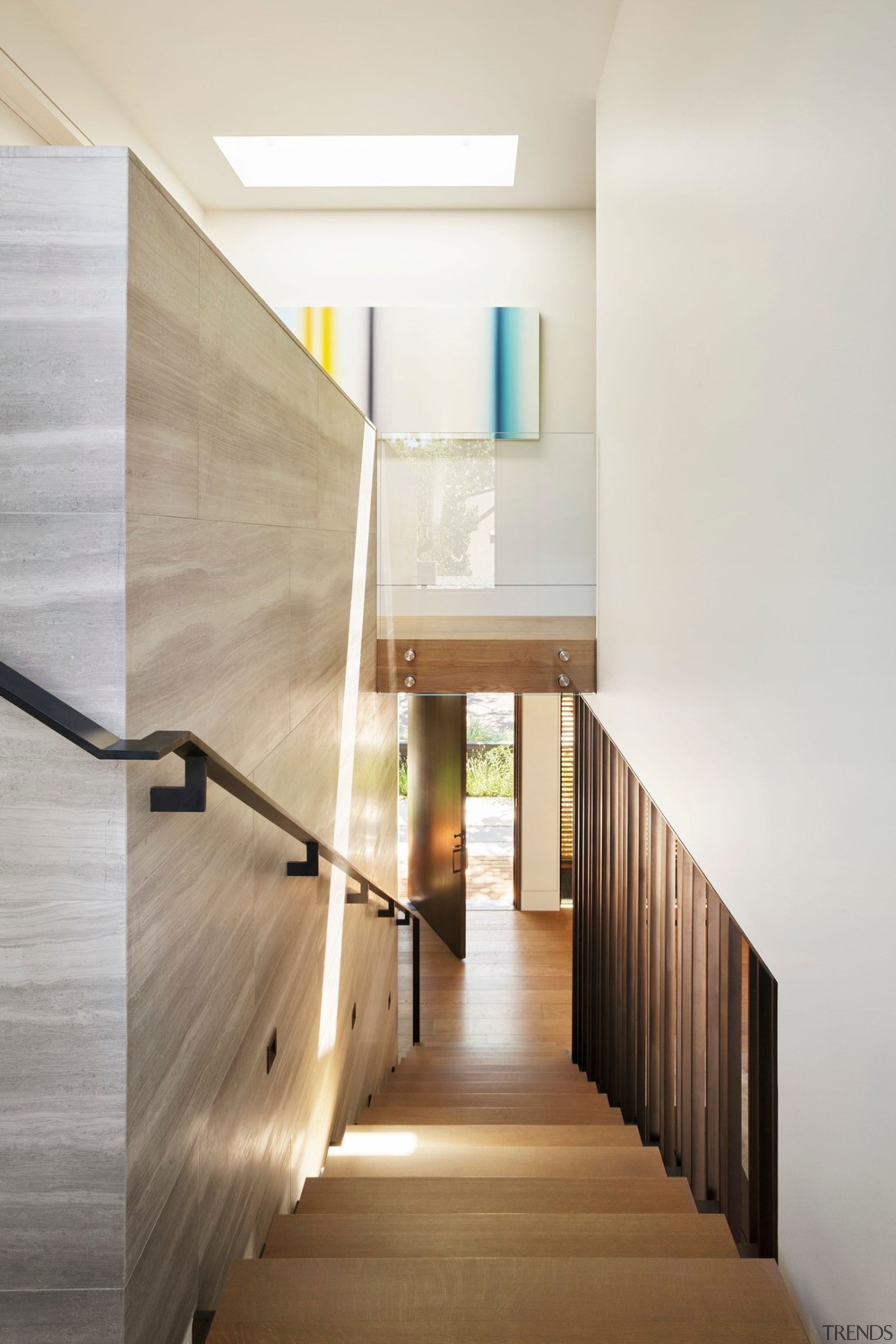 Light pours in from a skylight and a architecture, building, ceiling, daylighting, design, floor, flooring, hall, handrail, hardwood, home, house, interior design, line, material property, property, real estate, room, space, stairs, wall, wood, white