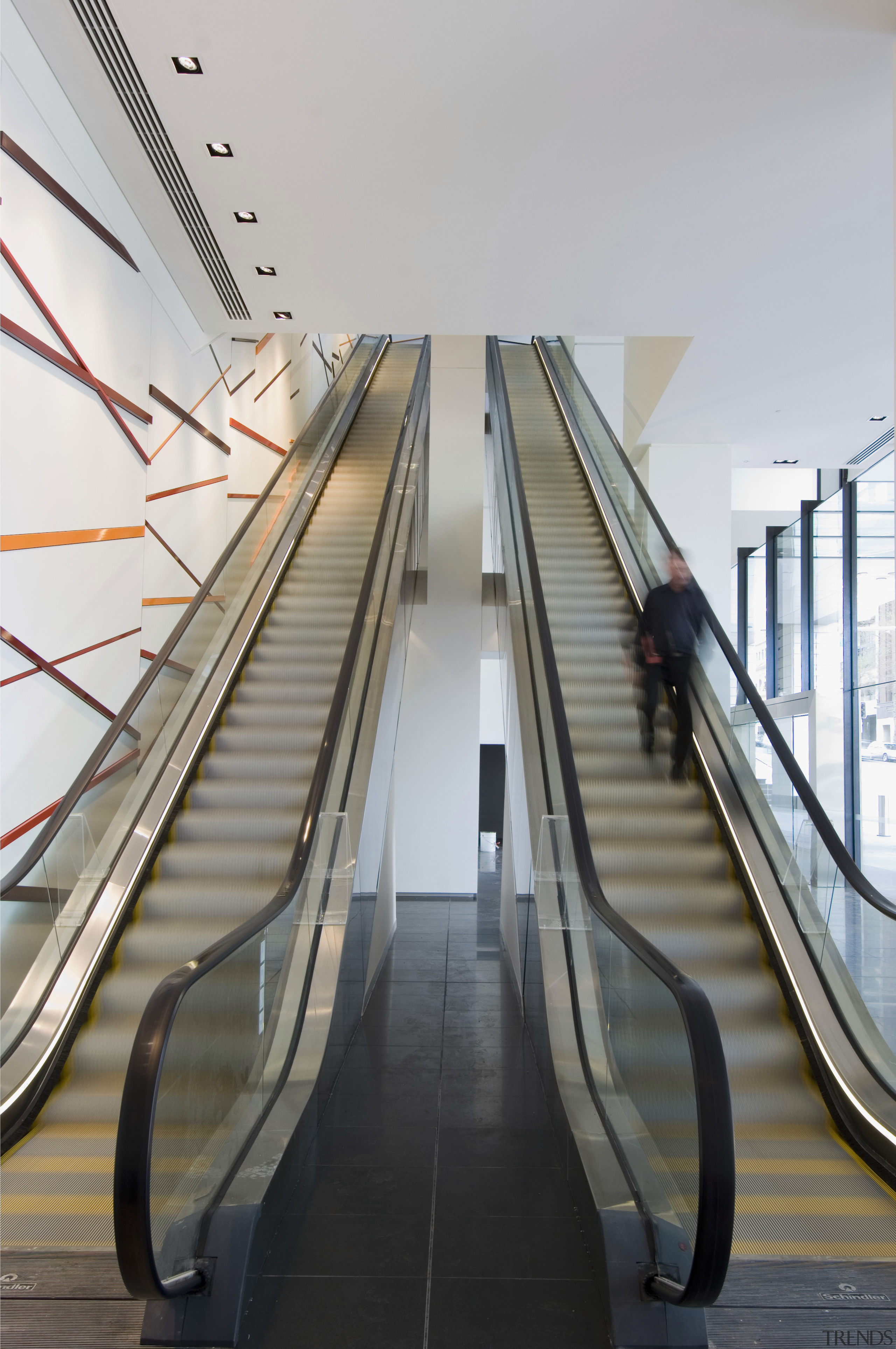 interior view of building featuring escalators, lighting, doors architecture, escalator, line, metropolitan area, stairs, structure, gray