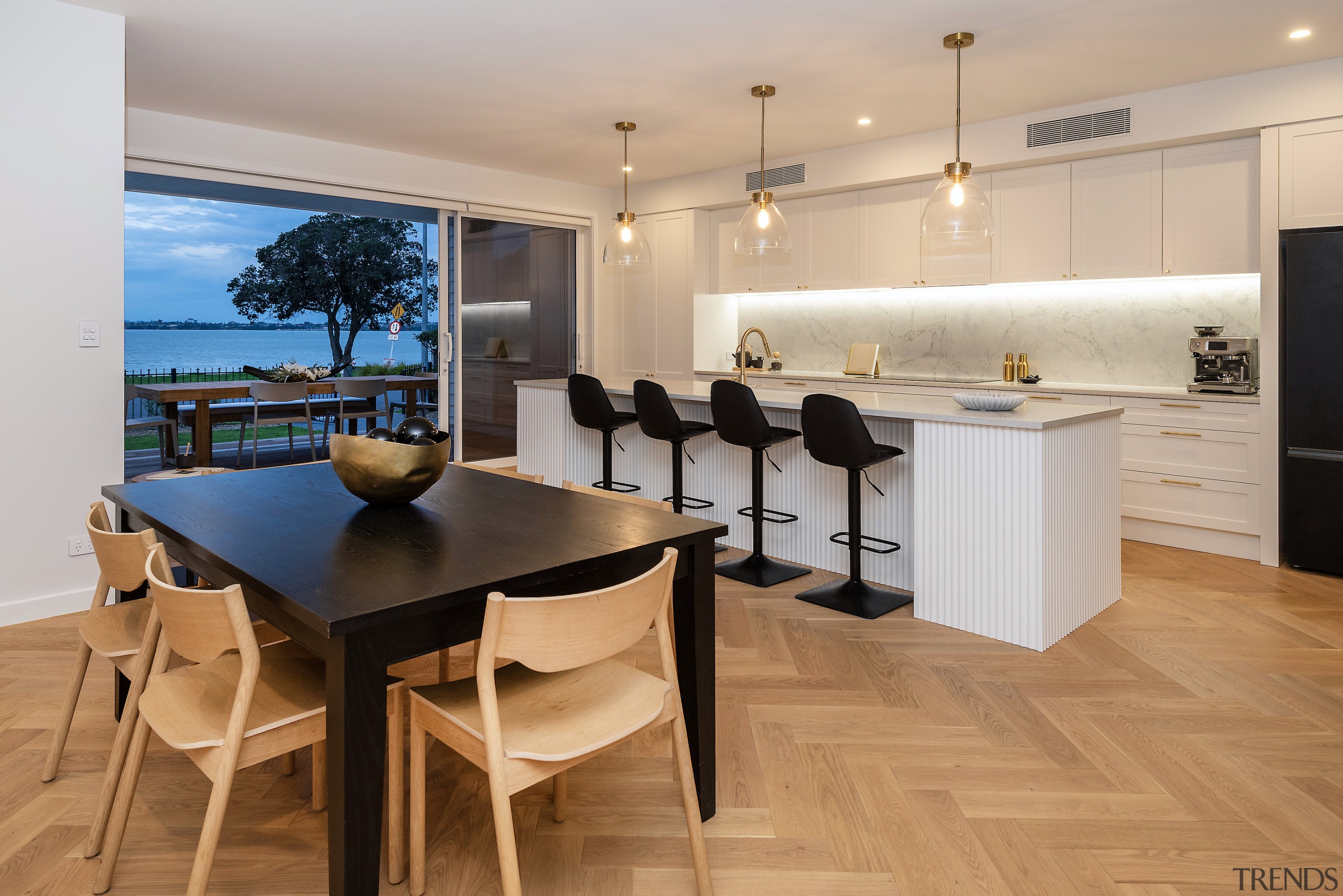Kitchen and dining with herringbone flooring. 