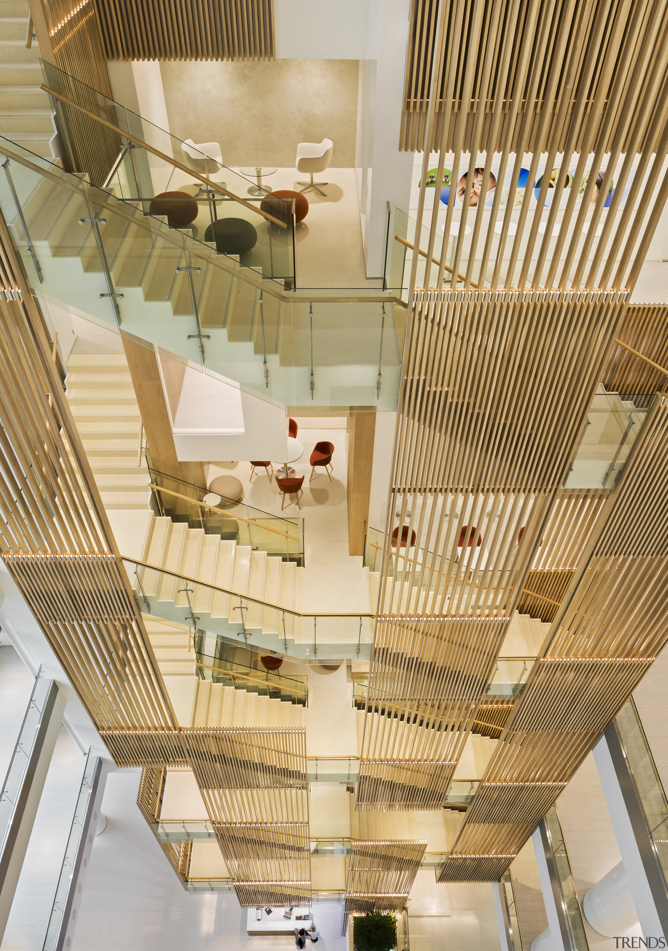 The staircase running through the atrium of this architecture, ceiling, daylighting, home, interior design, stairs, wood, orange, brown