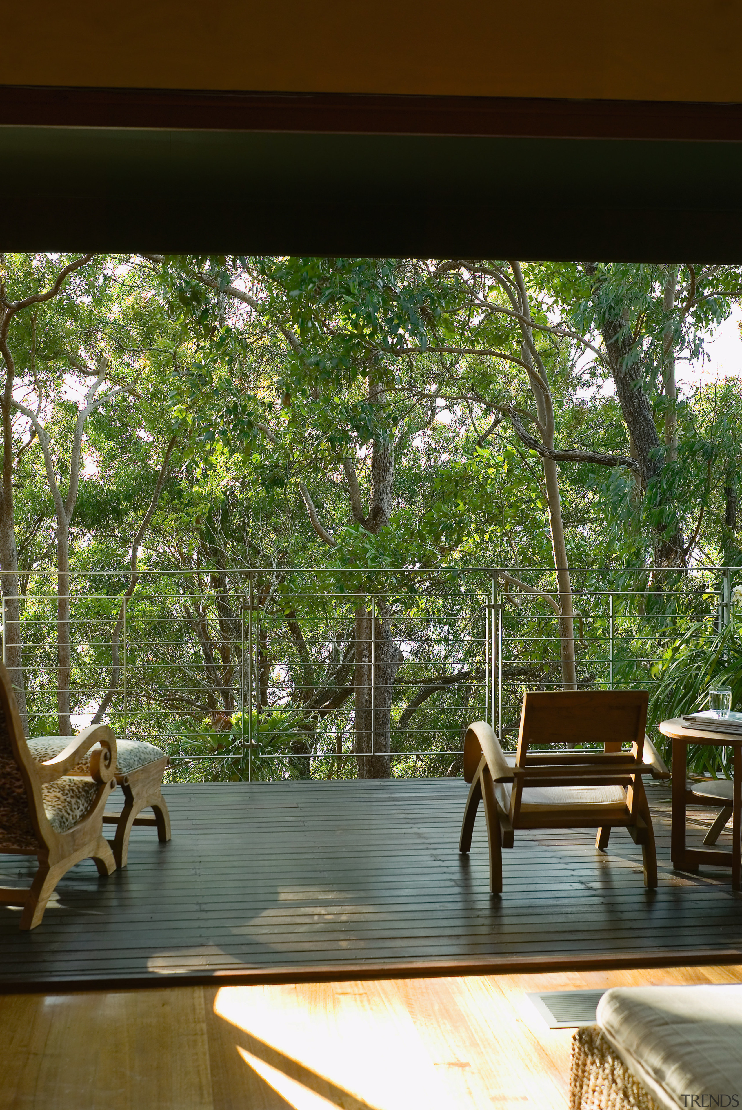 view from the ouitdoor balcony looking out into furniture, home, house, interior design, living room, outdoor furniture, outdoor structure, plant, table, tree, window, wood, brown