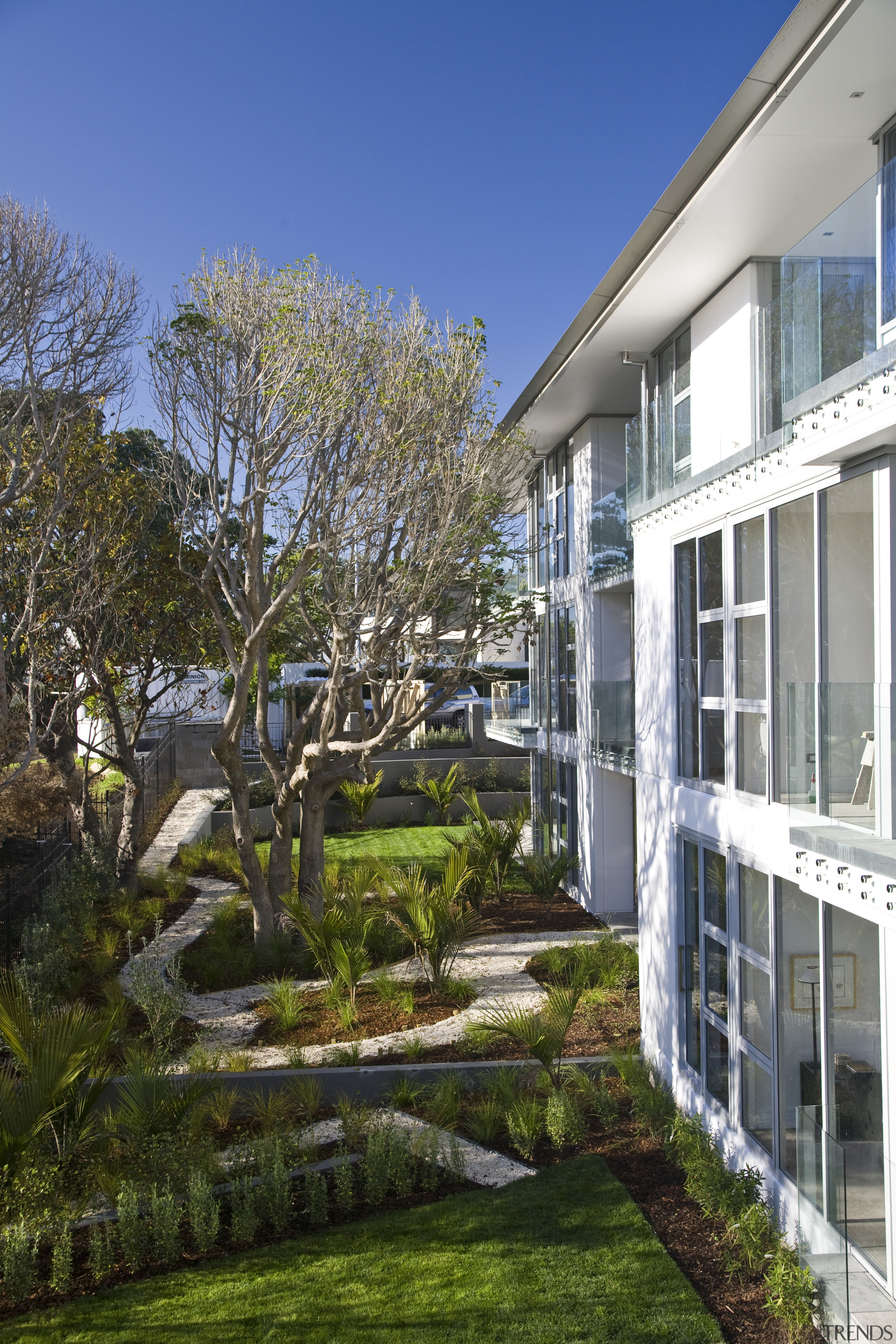 Exterior view of a Parnell apartment complex which apartment, architecture, backyard, building, condominium, cottage, estate, facade, home, house, landscape, landscaping, mixed use, neighbourhood, plant, property, real estate, residential area, tree, walkway, yard, brown