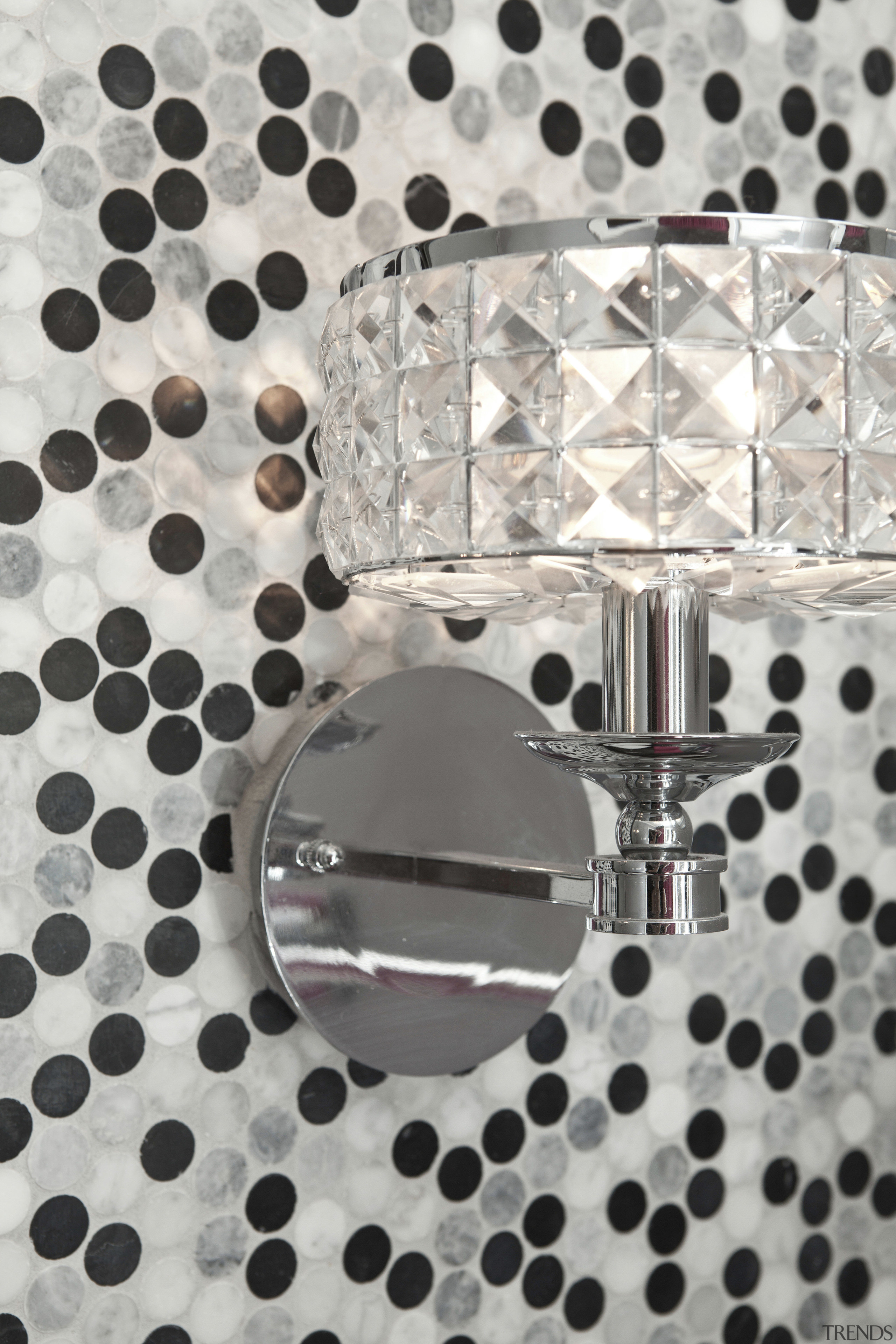 Close up of lamp with spotted wall covering. design, font, metal, pattern, polka dot, product, gray