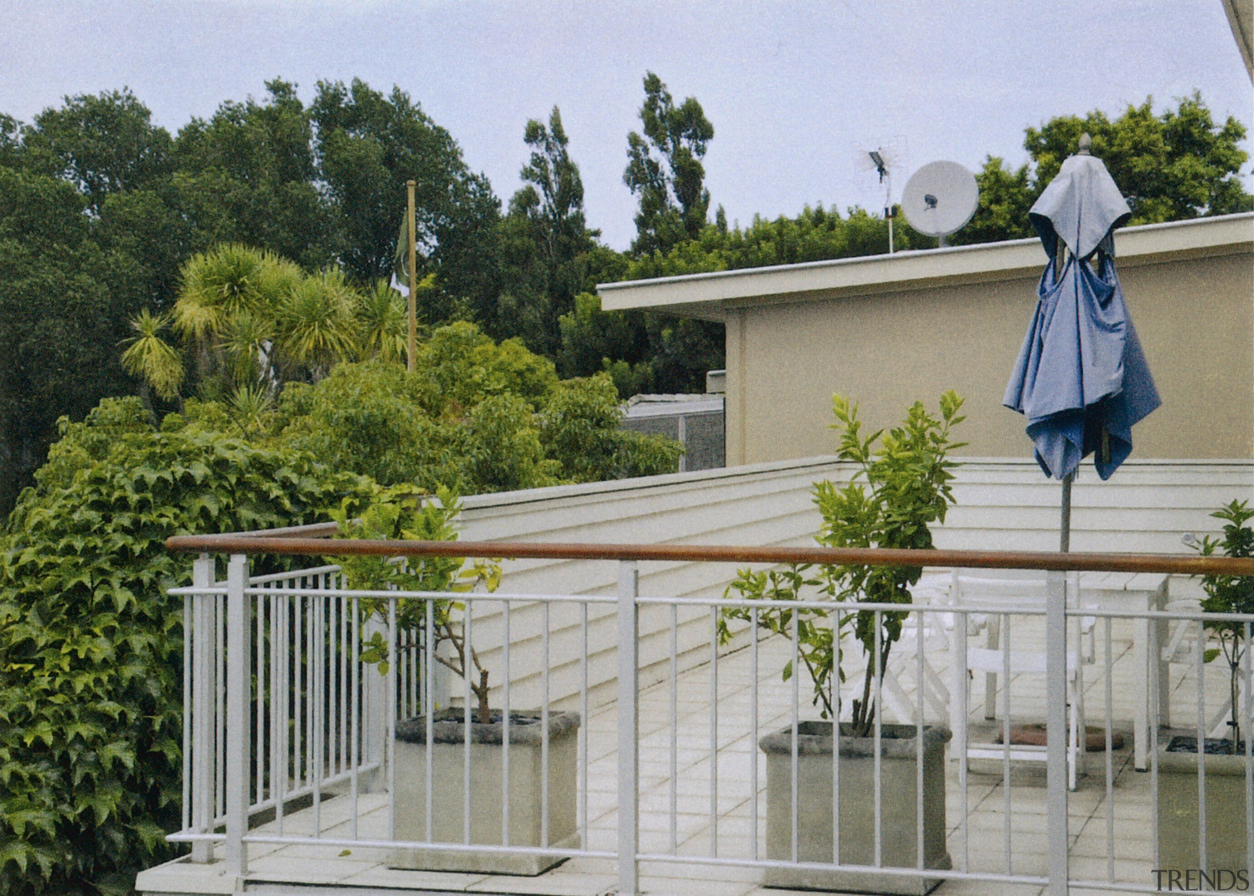 View of the upstairs balcony of home before fence, home, house, outdoor structure, property, real estate, residential area, roof, tree, gray