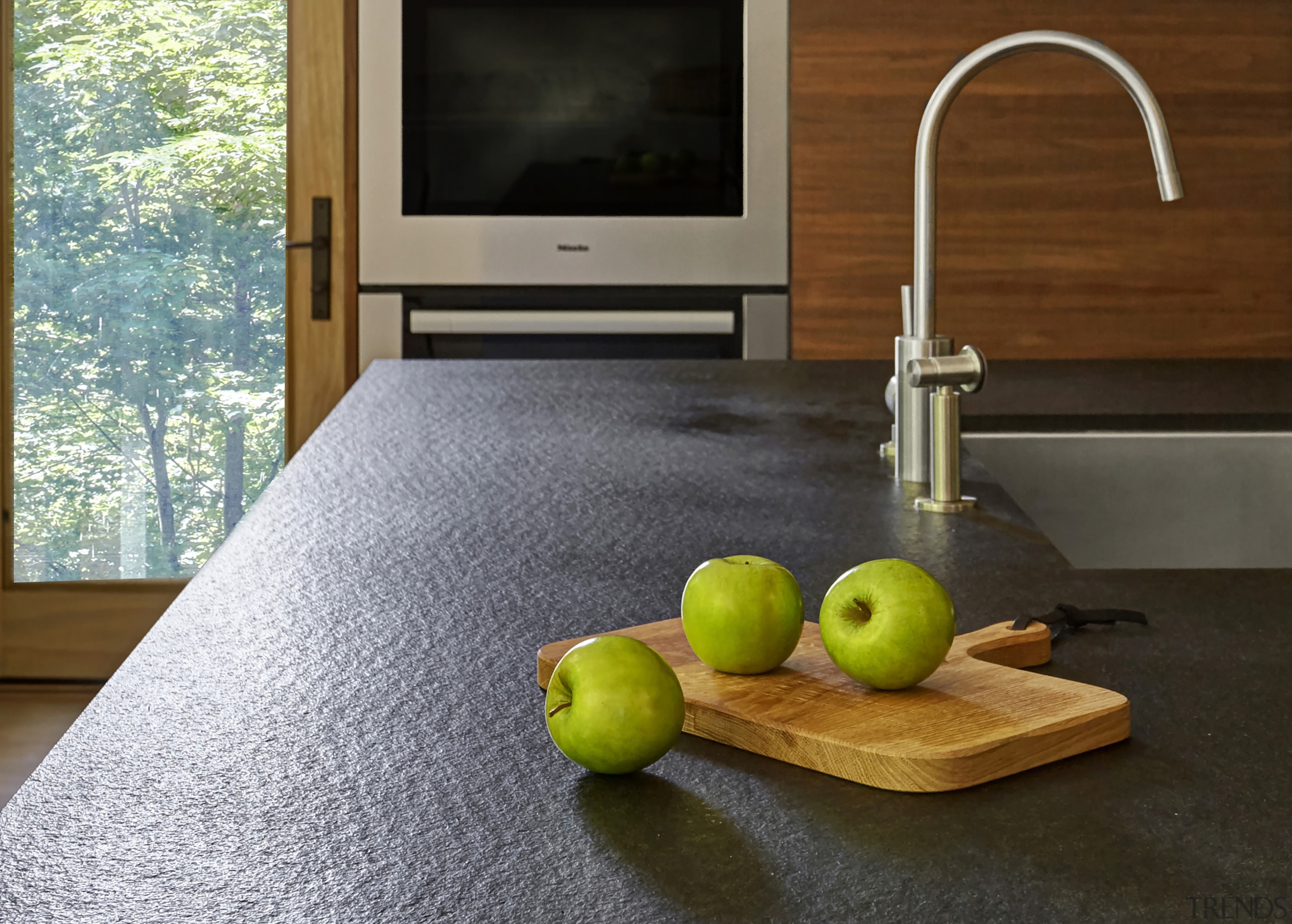 ​​​​​​​The brushed stone Absolute granite countertop on this countertop, floor, flooring, food, fruit, granite, hardwood, interior design, kitchen, plant, room, still life, still life photography, table, wood, black, gray