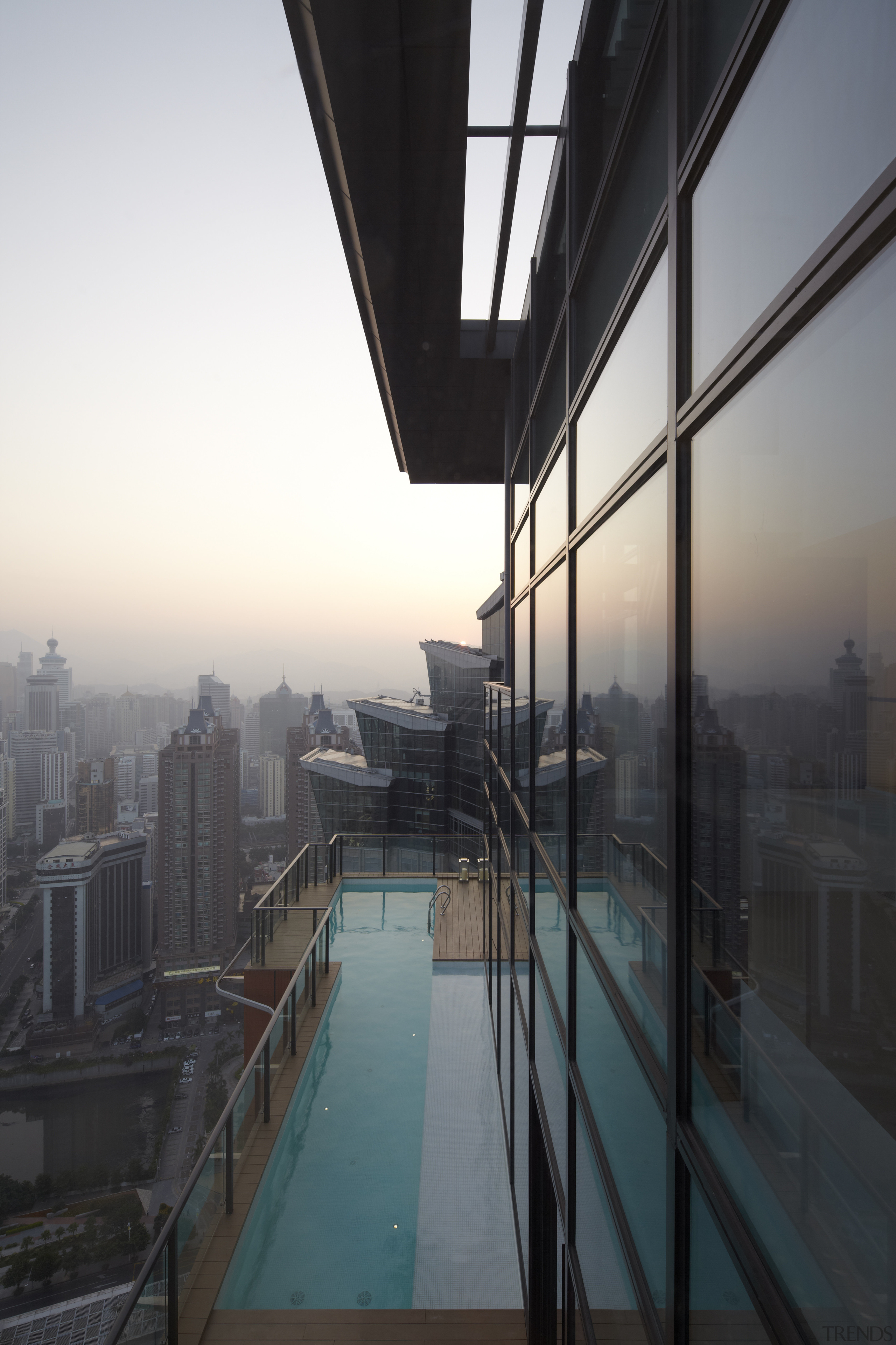 Views out across the lap pool in a apartment, architecture, building, condominium, daylighting, daytime, glass, house, morning, real estate, reflection, roof, sky, skyscraper, structure, sunlight, window, black, white