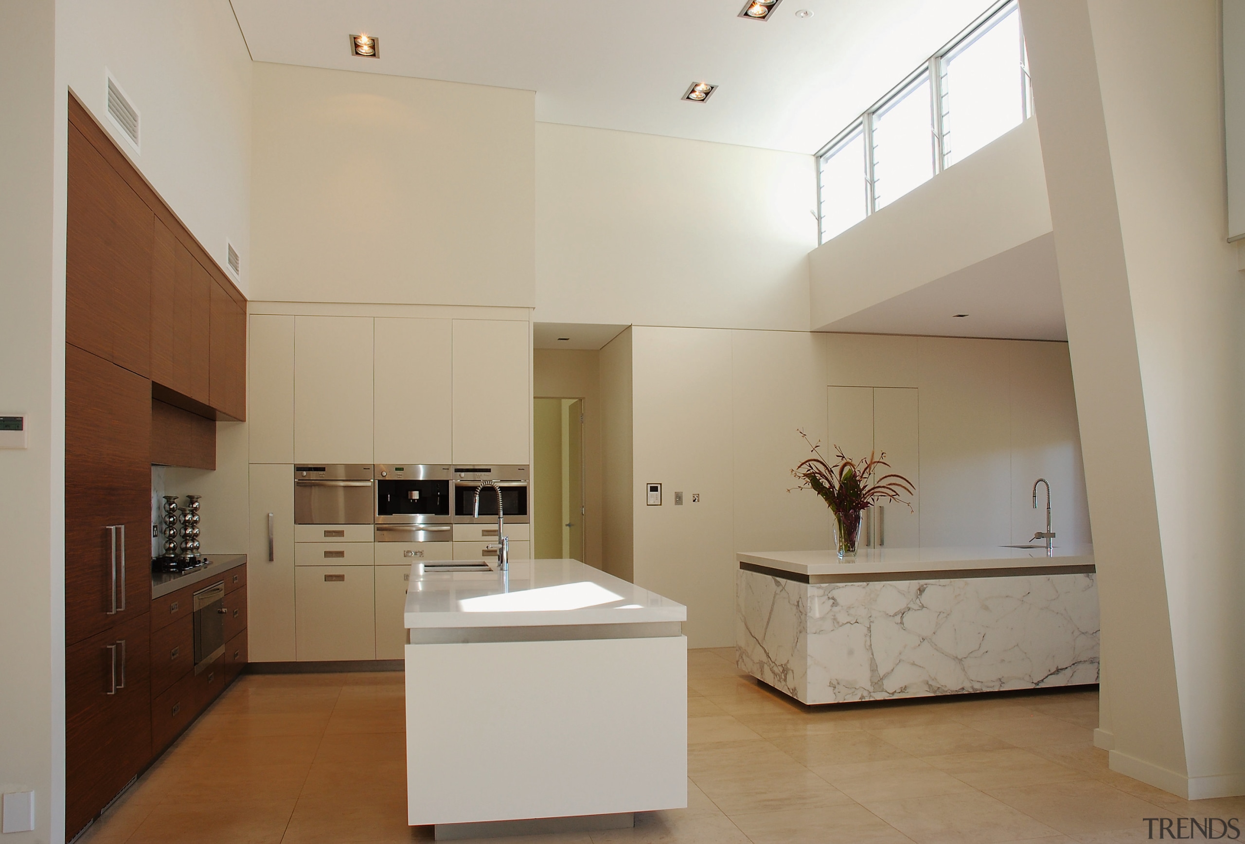 The island in this kitchen have benchtops of architecture, cabinetry, ceiling, countertop, daylighting, floor, home, interior design, kitchen, property, real estate, room, gray, brown