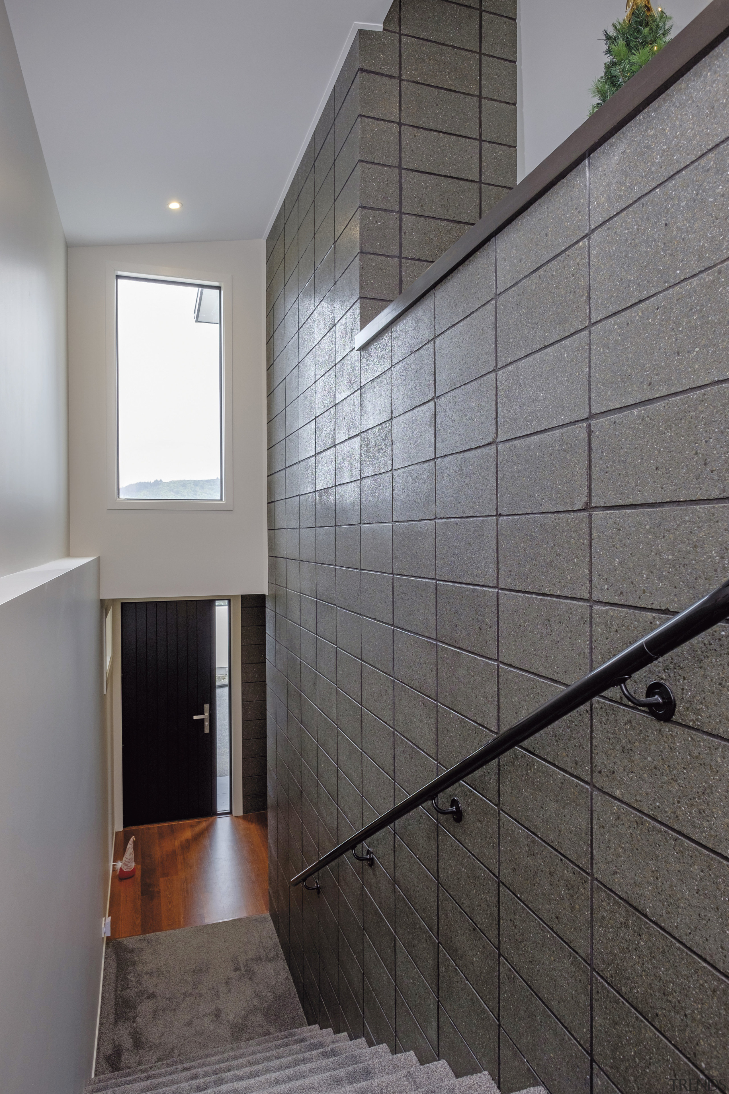 A welcoming double-height entrance with a honed, stacked architecture, bathroom, daylighting, floor, flooring, glass, handrail, home, house, interior design, room, tile, wall, gray