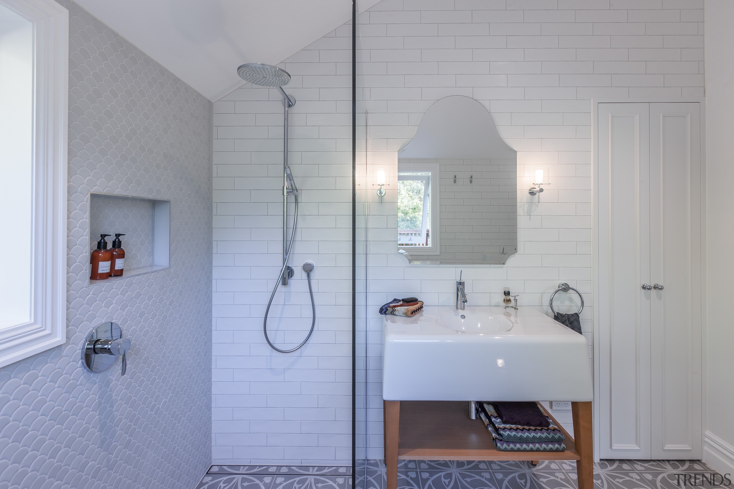 This bathroom by designer Natalie Du Bois incorporates architecture, bathroom, bathroom accessory, floor, home, house, interior design, plumbing fixture, room, sink, tap, tile, wall, gray