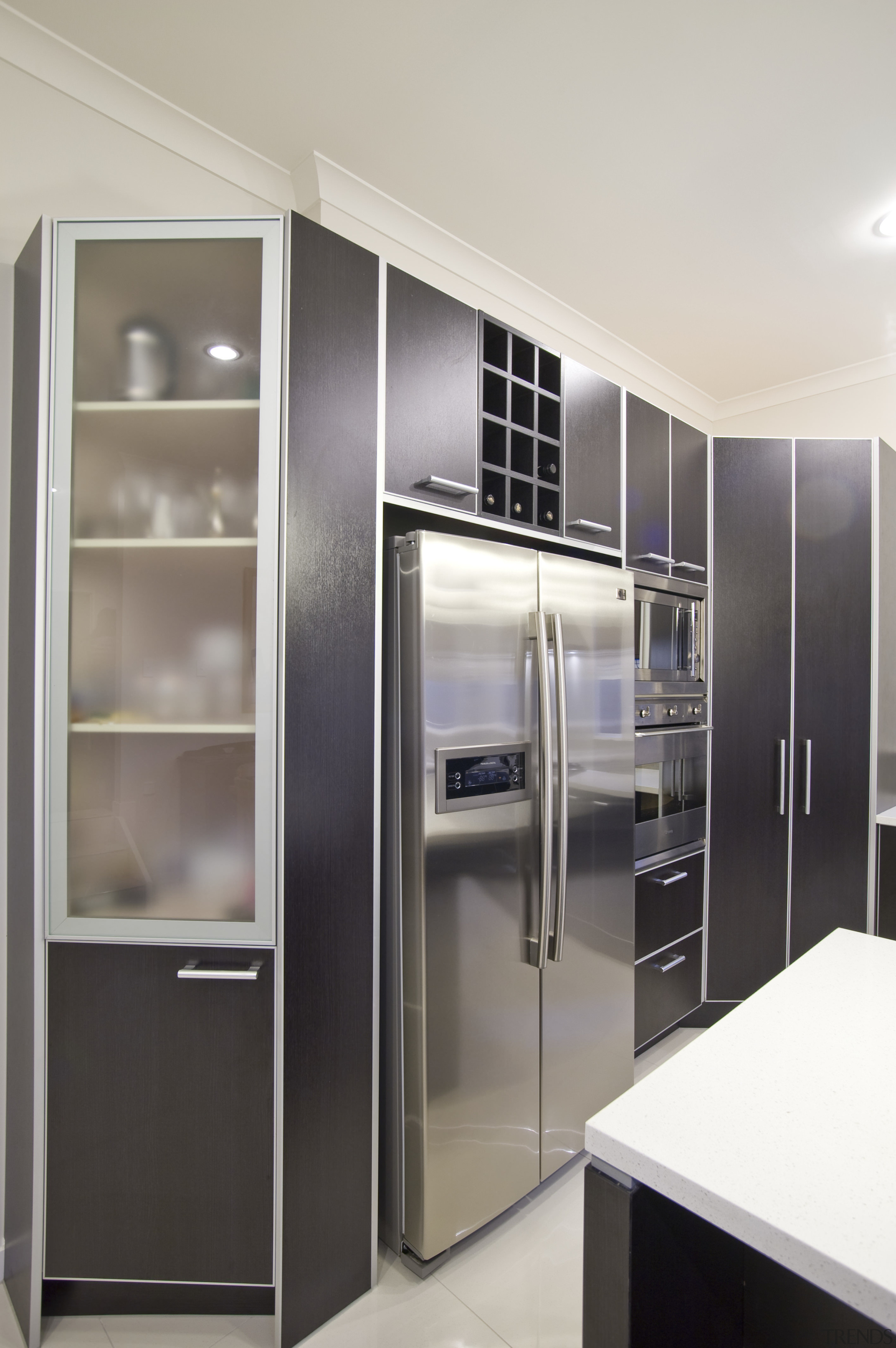 View of a kitchen which features dark stained cabinetry, door, furniture, home appliance, interior design, kitchen, major appliance, refrigerator, wardrobe, white, gray