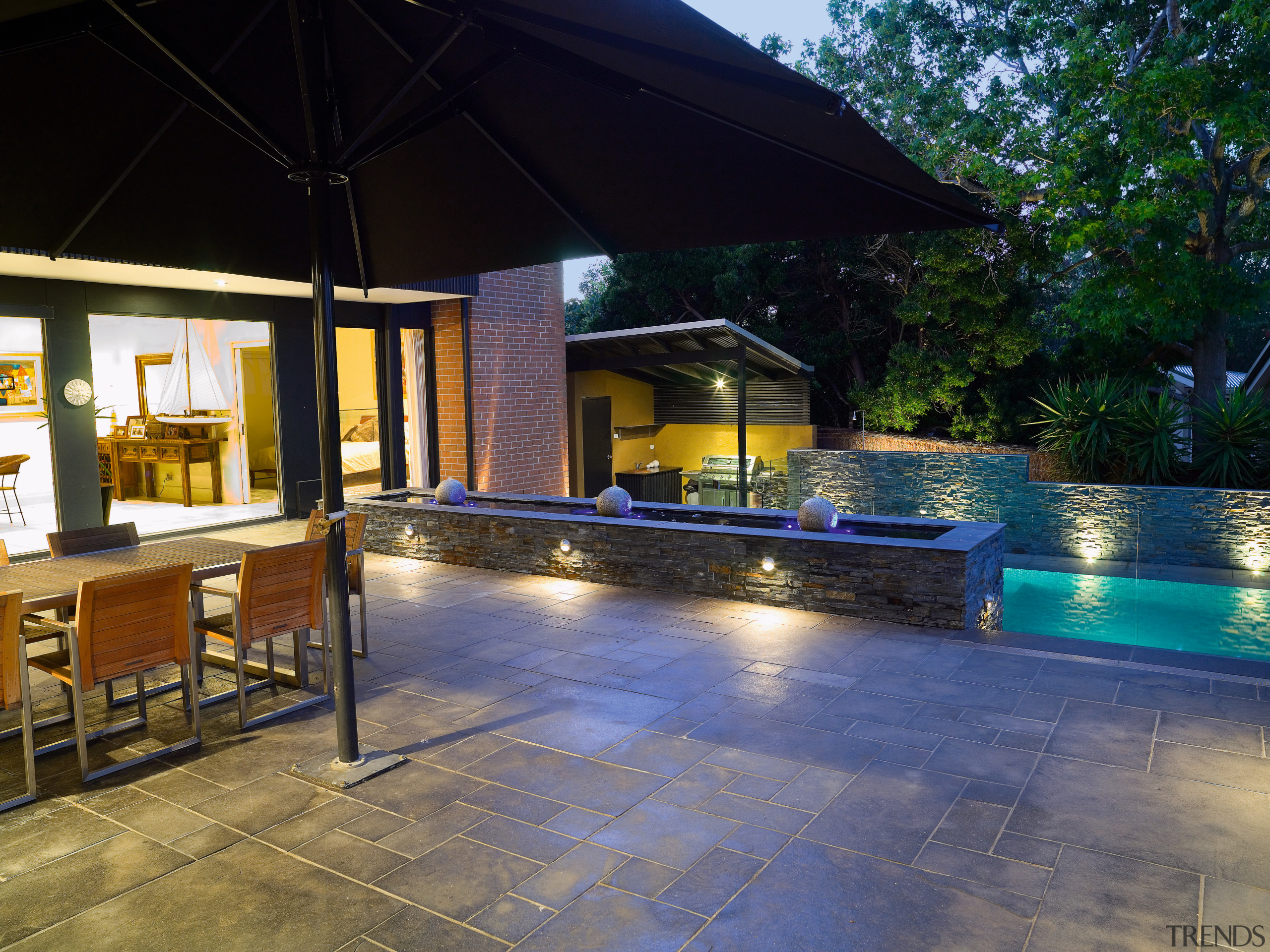 View of the outdoor entertainment area featuring outdoor backyard, estate, home, leisure, lighting, outdoor structure, patio, property, real estate, resort, swimming pool, black