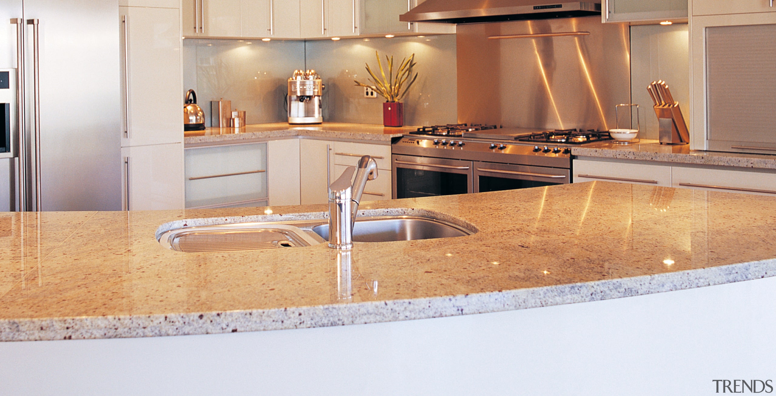 Kitchen with curved granite island benchtop, stainless steel countertop, cuisine classique, floor, flooring, interior design, kitchen, under cabinet lighting, orange, white