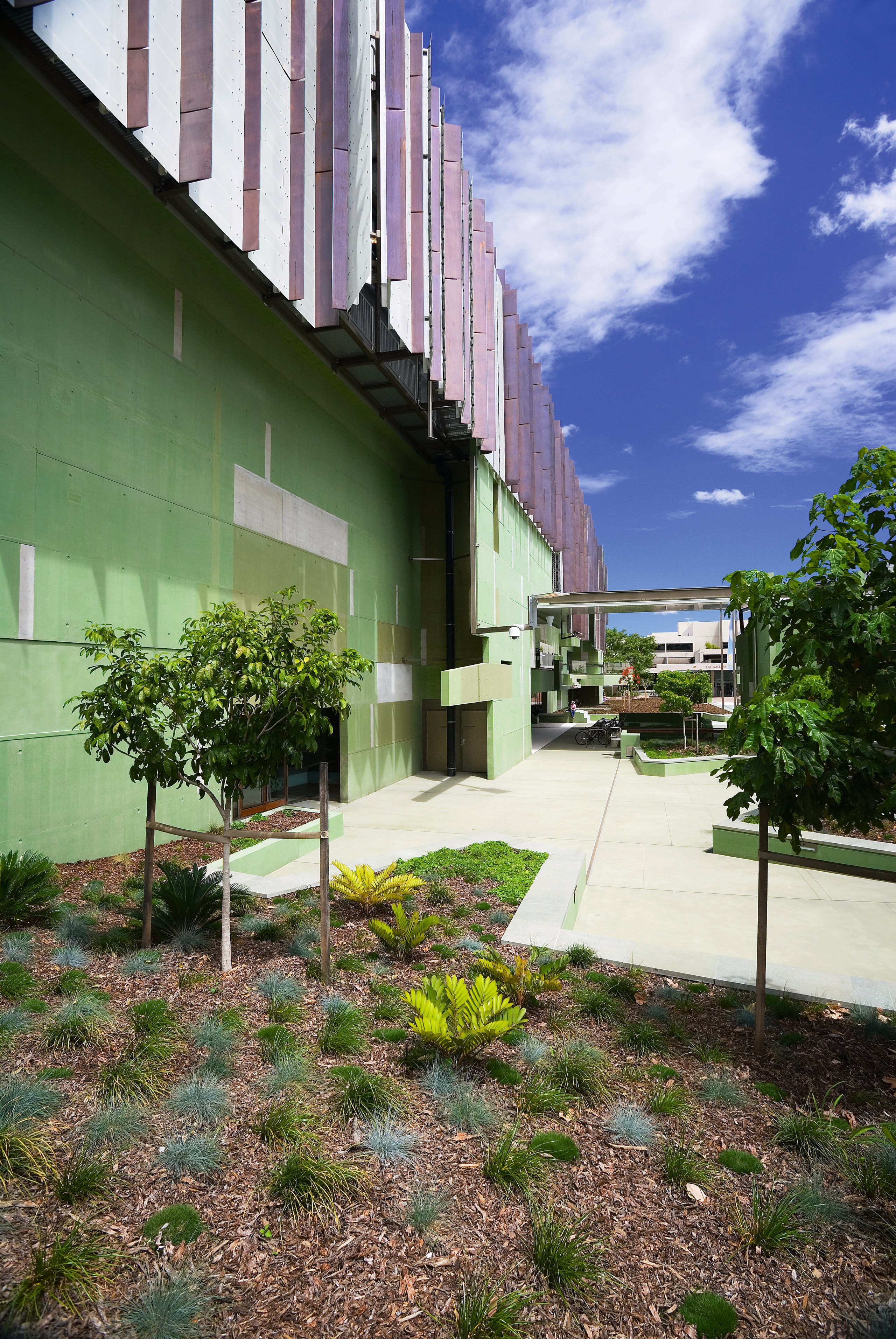 A view of some landscaping by Dig It apartment, architecture, building, condominium, daytime, estate, facade, grass, home, house, neighbourhood, real estate, residential area, sky, tree, brown