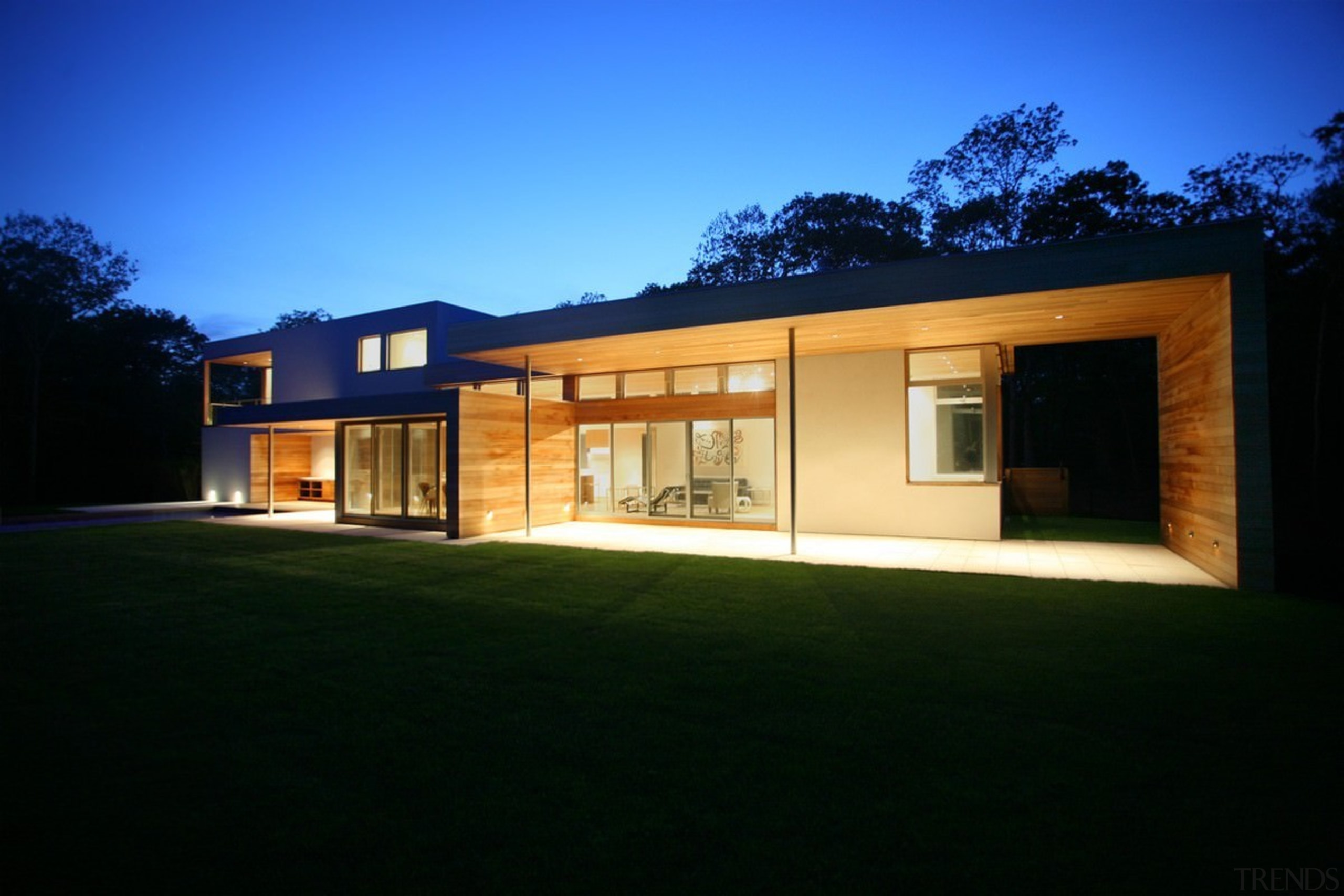 A view of the home at night - architecture, cottage, elevation, estate, facade, home, house, lighting, property, real estate, residential area, siding, sky, window, black, blue