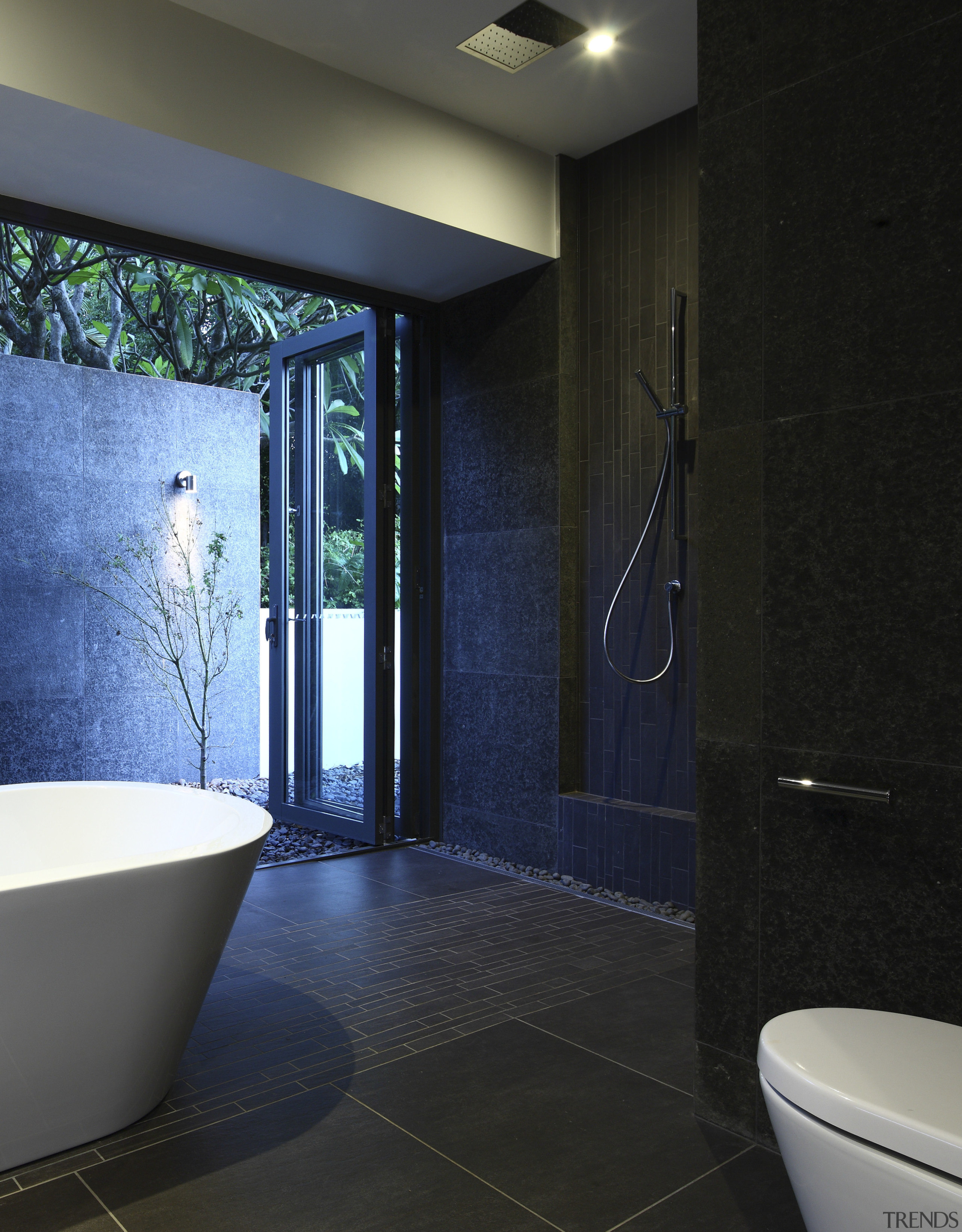 View of dark-toned bathroom with white tub. - architecture, bathroom, ceiling, daylighting, floor, flooring, glass, home, interior design, room, tile, wall, black