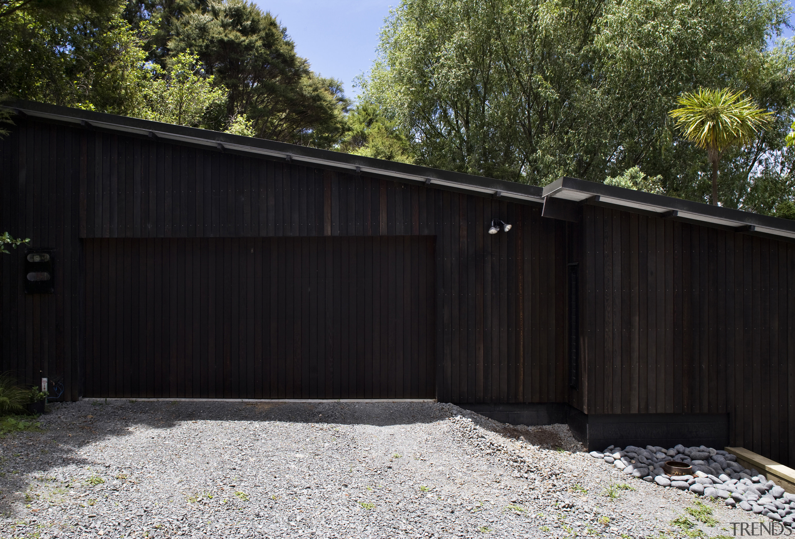 The timber for this house is treated with backyard, facade, fence, garage, garage door, house, outdoor structure, property, real estate, shed, siding, wood, yard, black