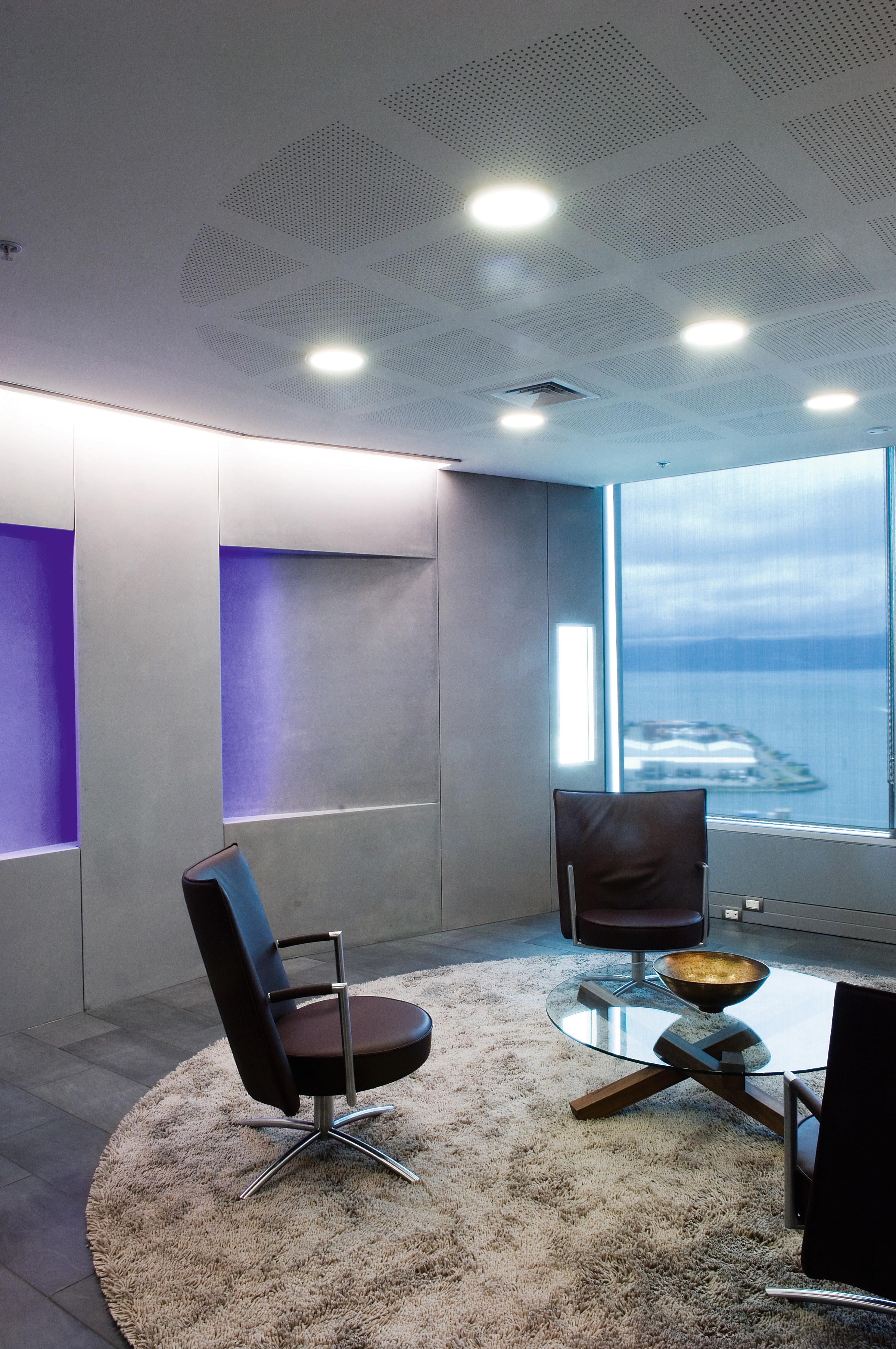 A view of soft ambient lighting supplied by architecture, ceiling, daylighting, floor, furniture, interior design, office, table, wall, gray