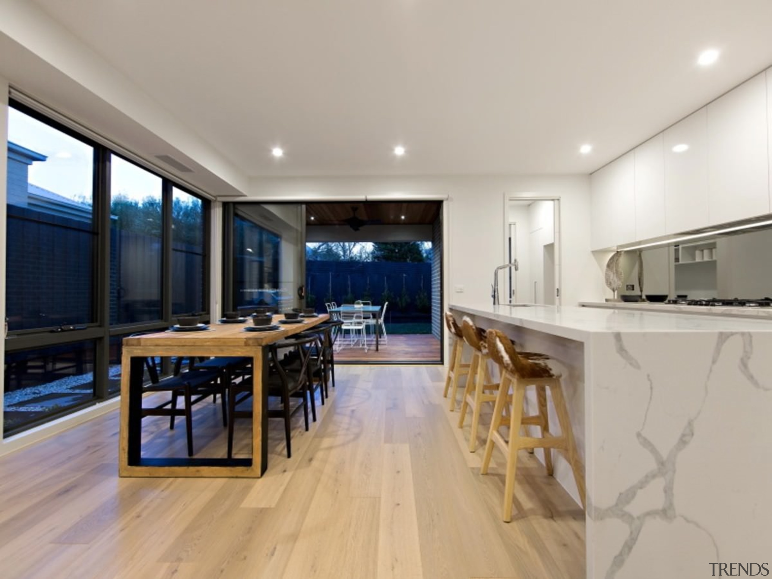 The dining table is flanked by large windows floor, flooring, hardwood, interior design, kitchen, property, real estate, wood flooring, gray