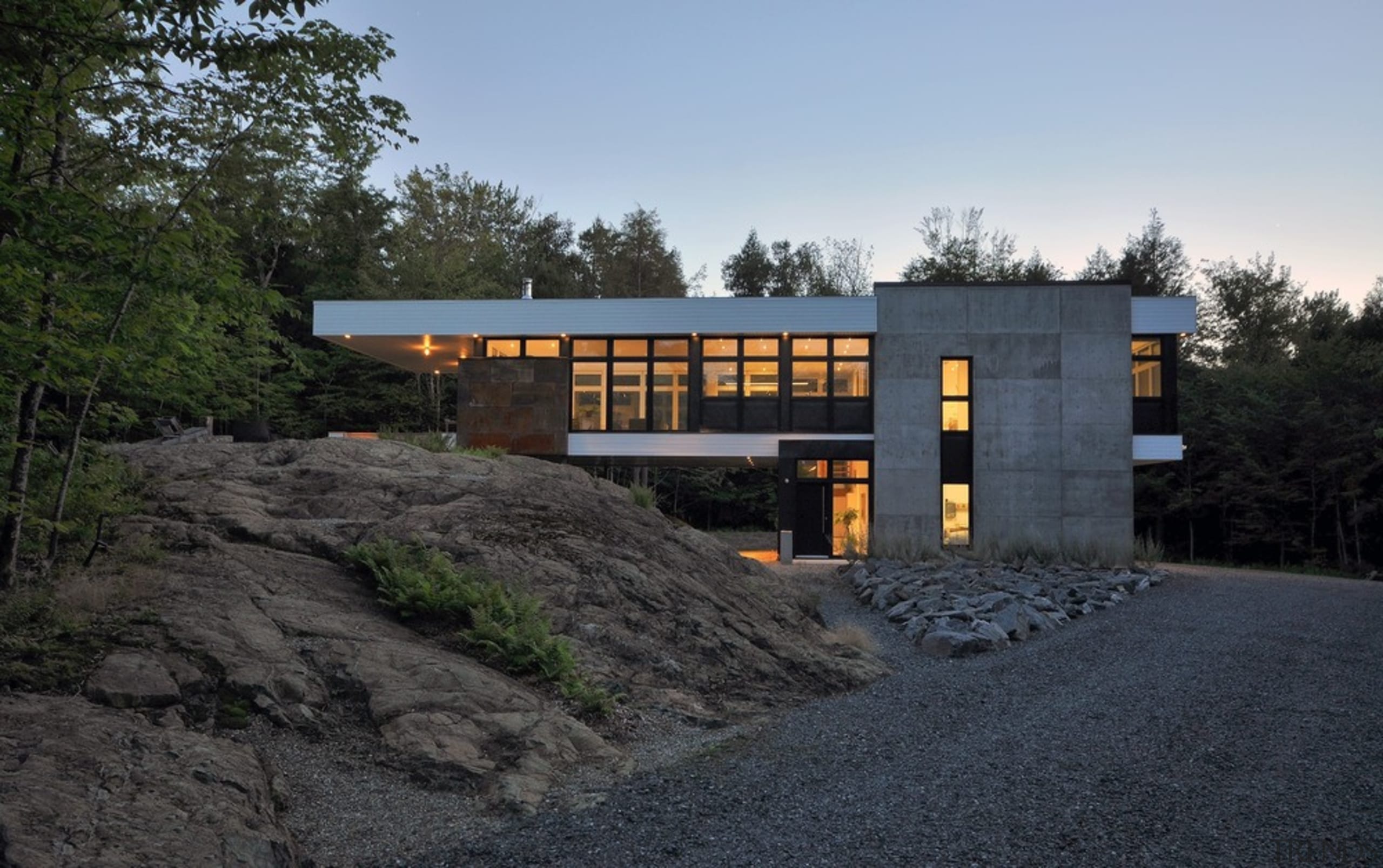 The structure stretches from the rock mound to architecture, building, cottage, facade, home, house, landscape, property, real estate, sky, black