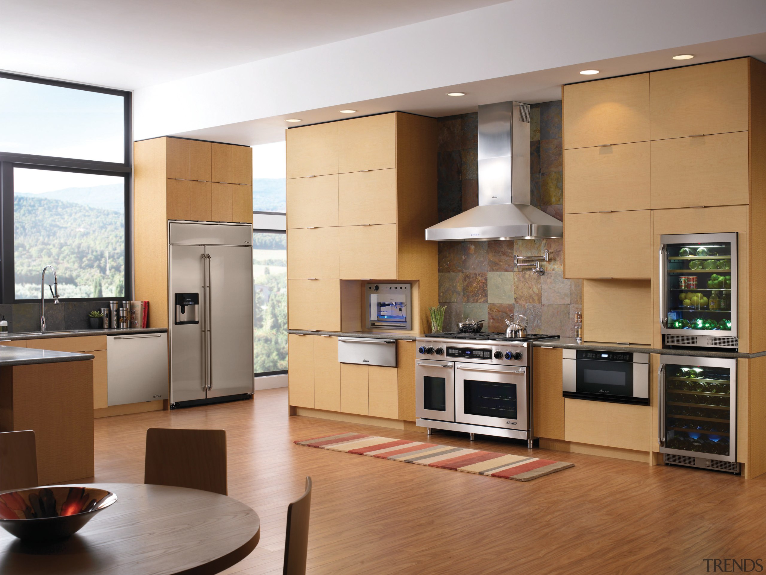 A view of this kitchen featuring the latest cabinetry, countertop, cuisine classique, floor, flooring, hardwood, home appliance, interior design, kitchen, living room, room, wood flooring, brown, gray