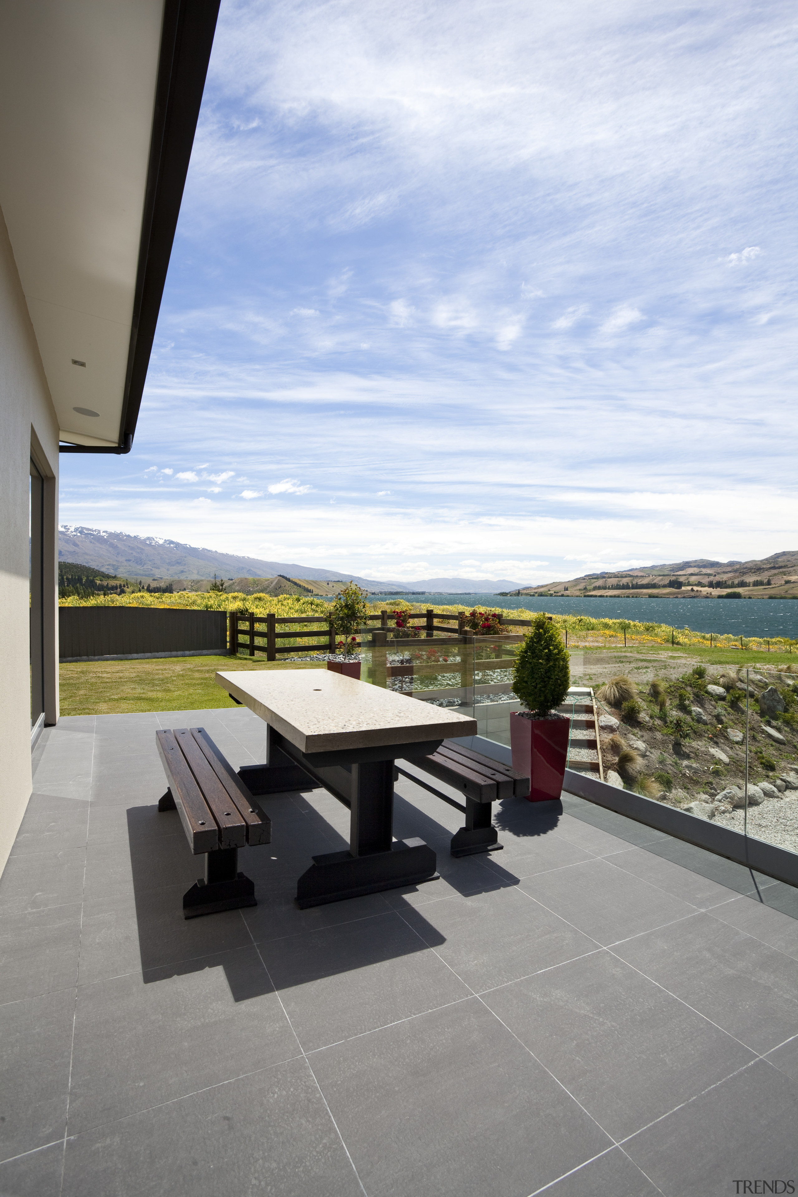 The flooring for this Otago home was chosen architecture, cloud, condominium, home, house, outdoor furniture, property, real estate, roof, sky, sunlounger, table, white, gray