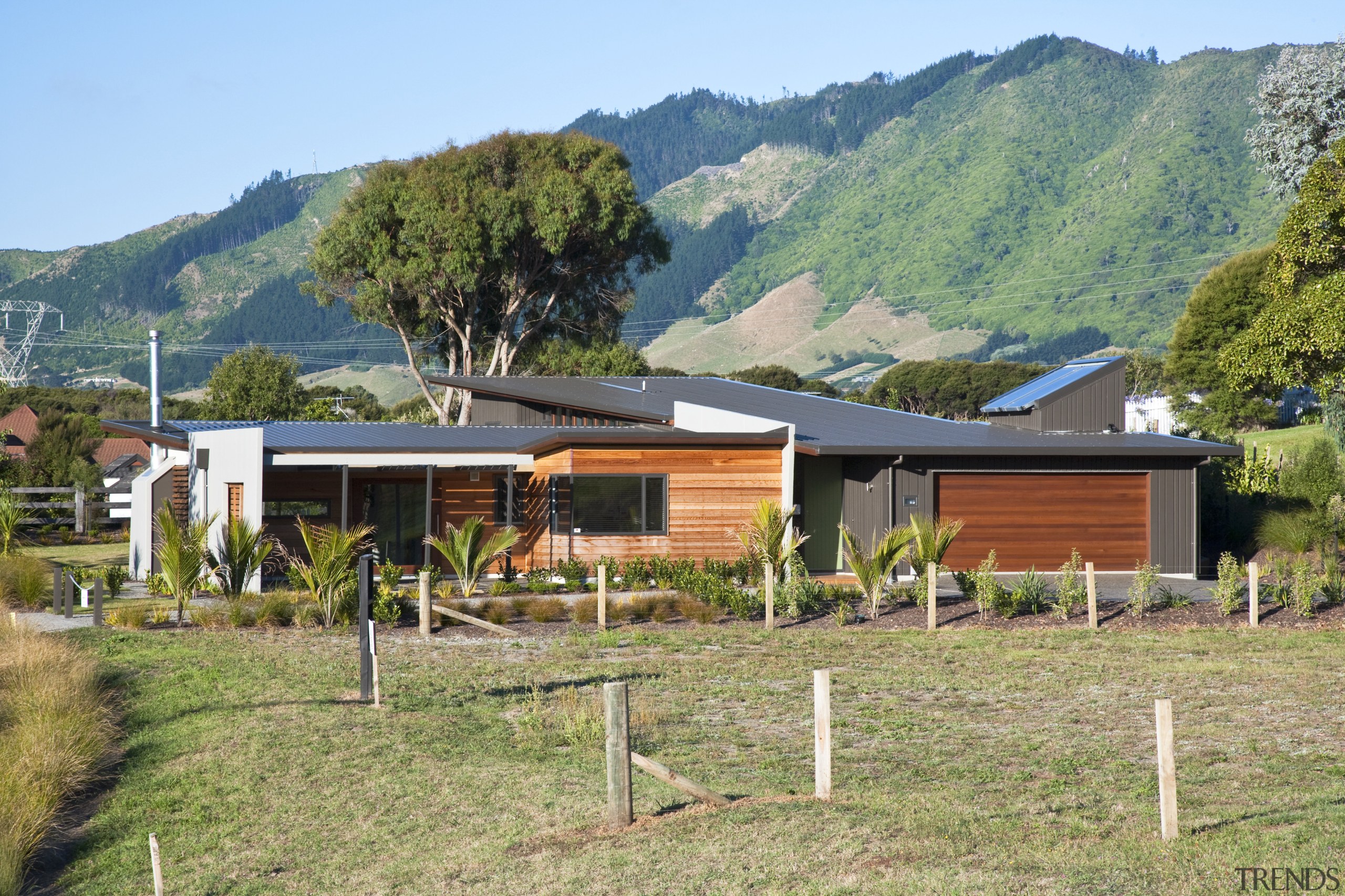 Exterior view of a home which is part cottage, facade, farmhouse, home, house, land lot, landscape, property, real estate, rural area, brown