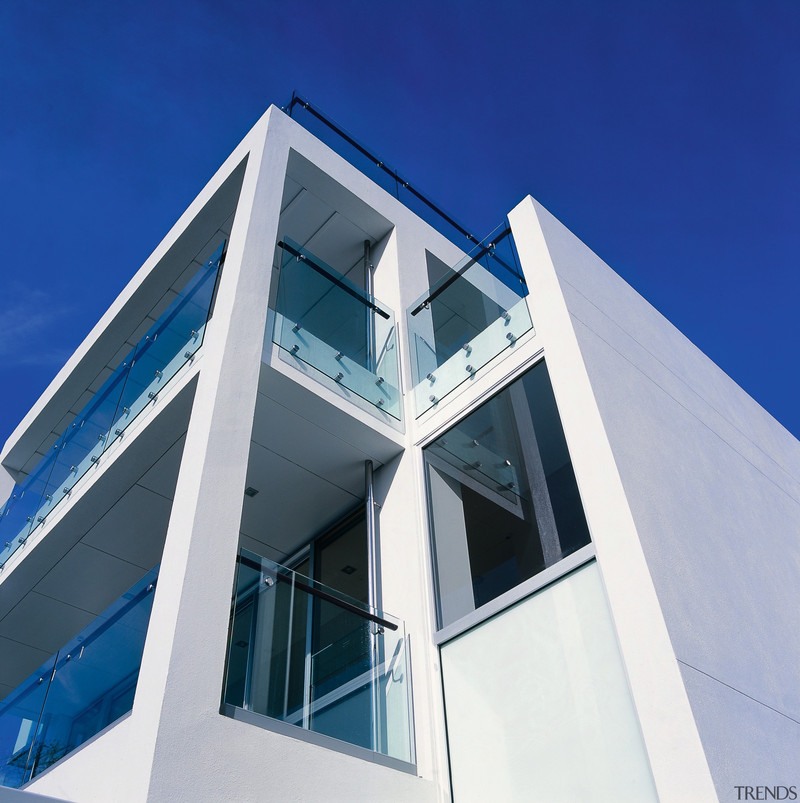 An exterior view of the apartments, plastered walls, architecture, building, commercial building, corporate headquarters, daylighting, daytime, elevation, facade, home, house, property, real estate, sky, structure, window, blue