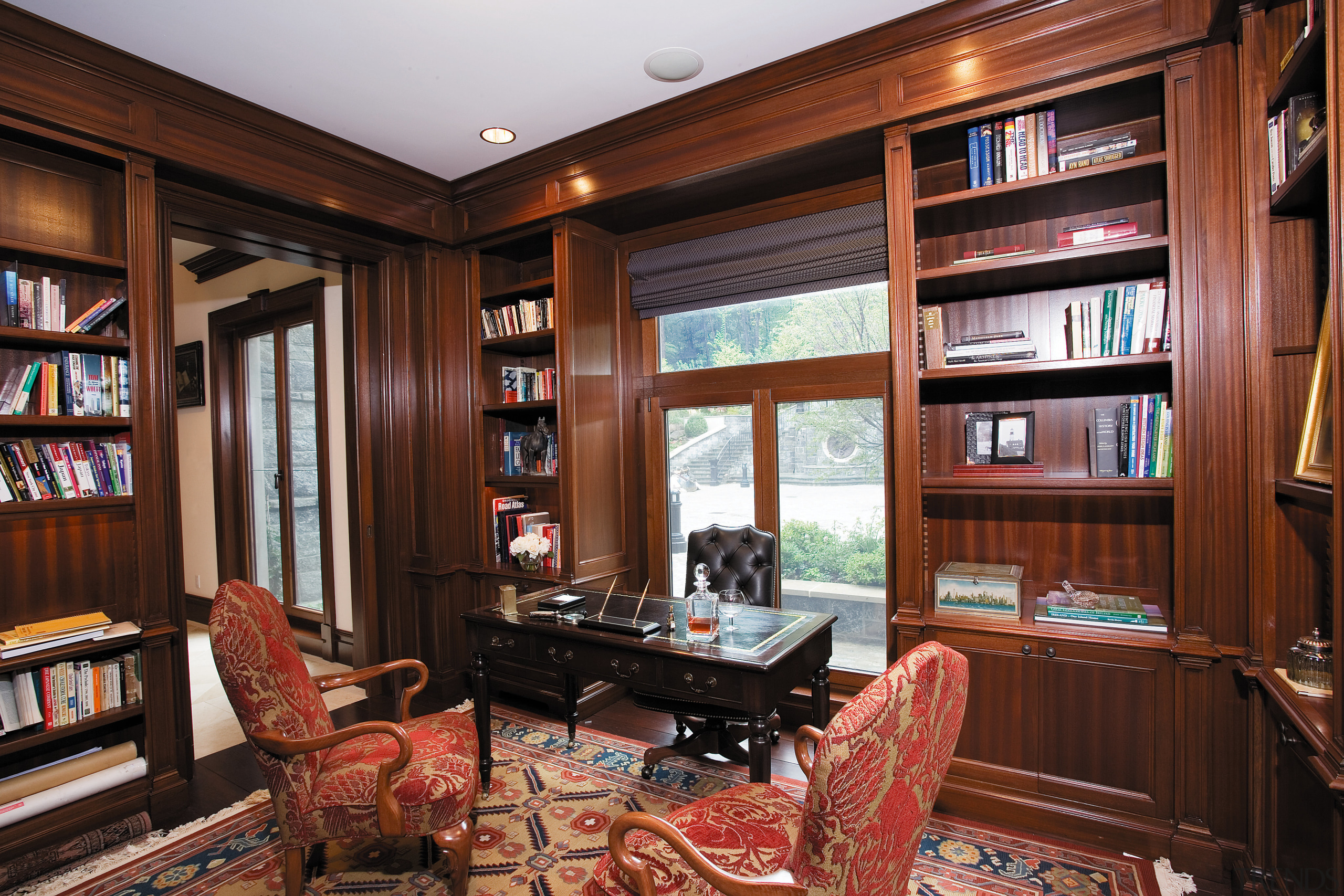 Interior view of the living area featuring  bookcase, cabinetry, furniture, interior design, library, living room, shelving, red