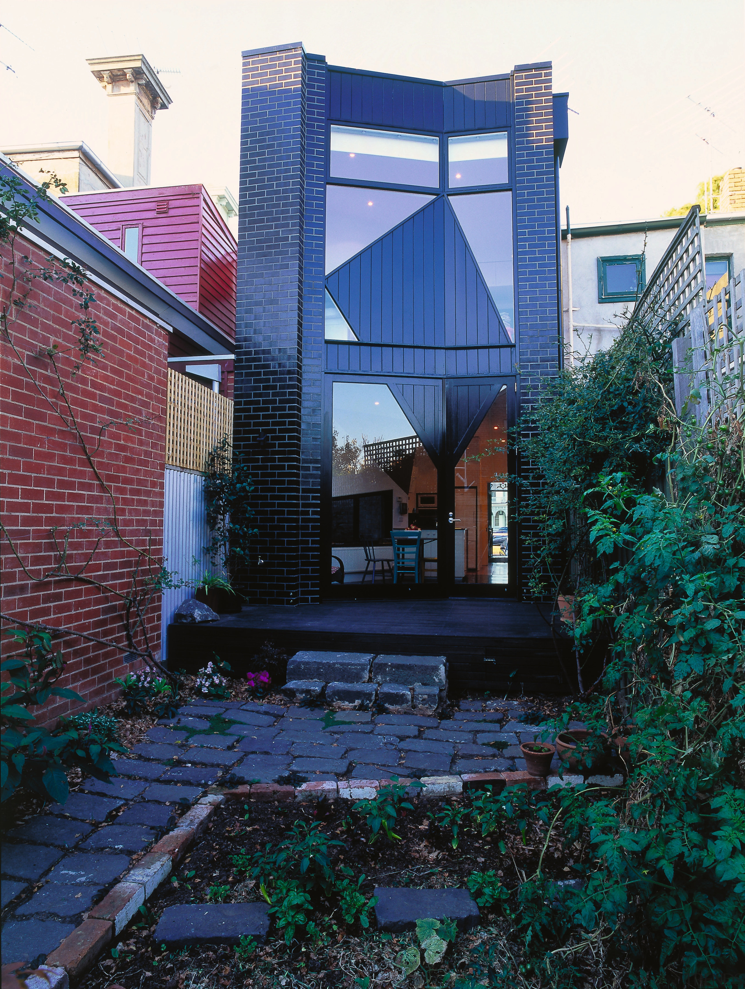 view of this cottage that was rebuilt showing architecture, building, facade, home, house, outdoor structure, real estate, reflection, residential area, roof, tree, window, black, blue
