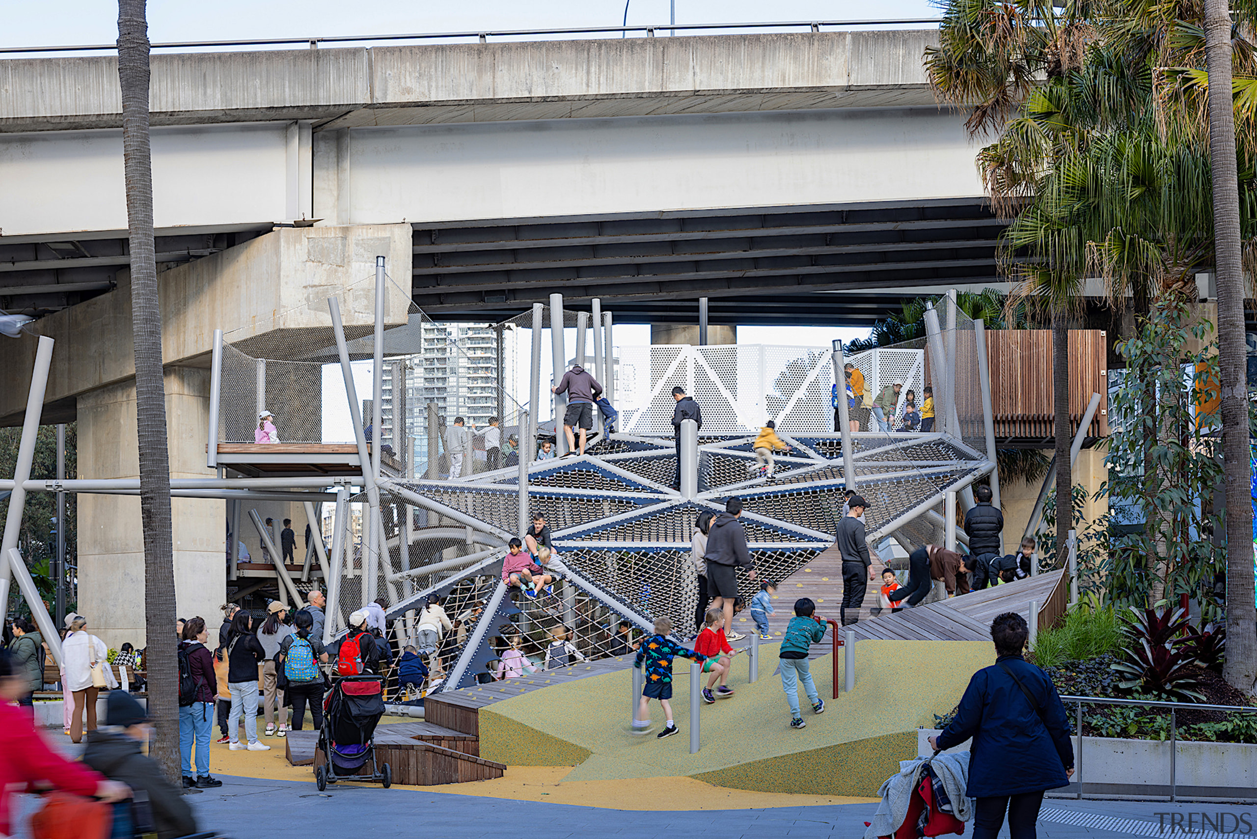 The playground is shaded by the motorway flyover. 