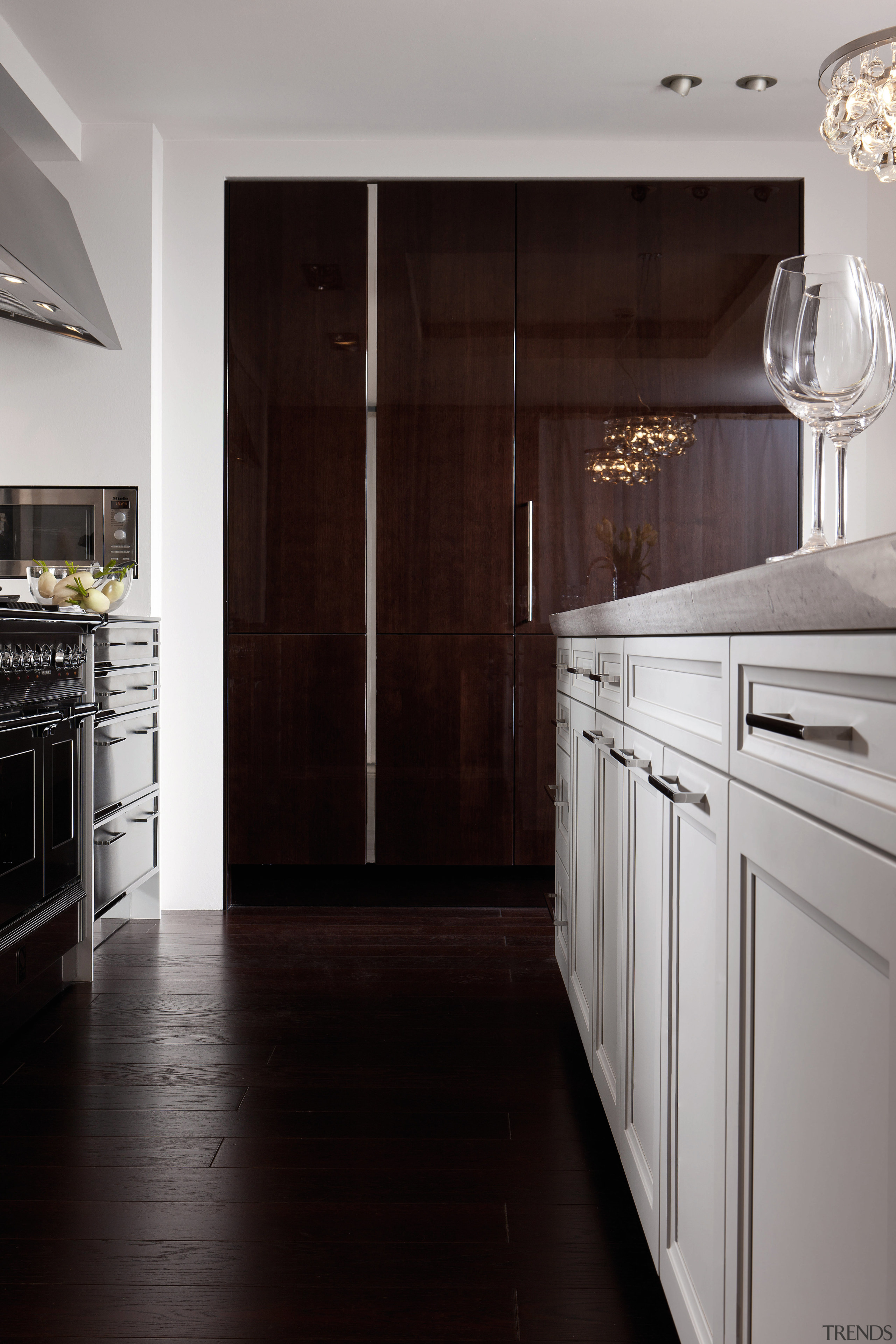 View of kitchen with dark wooden flooring and cabinetry, countertop, cuisine classique, floor, flooring, home appliance, interior design, kitchen, major appliance, room, wood flooring, black, gray