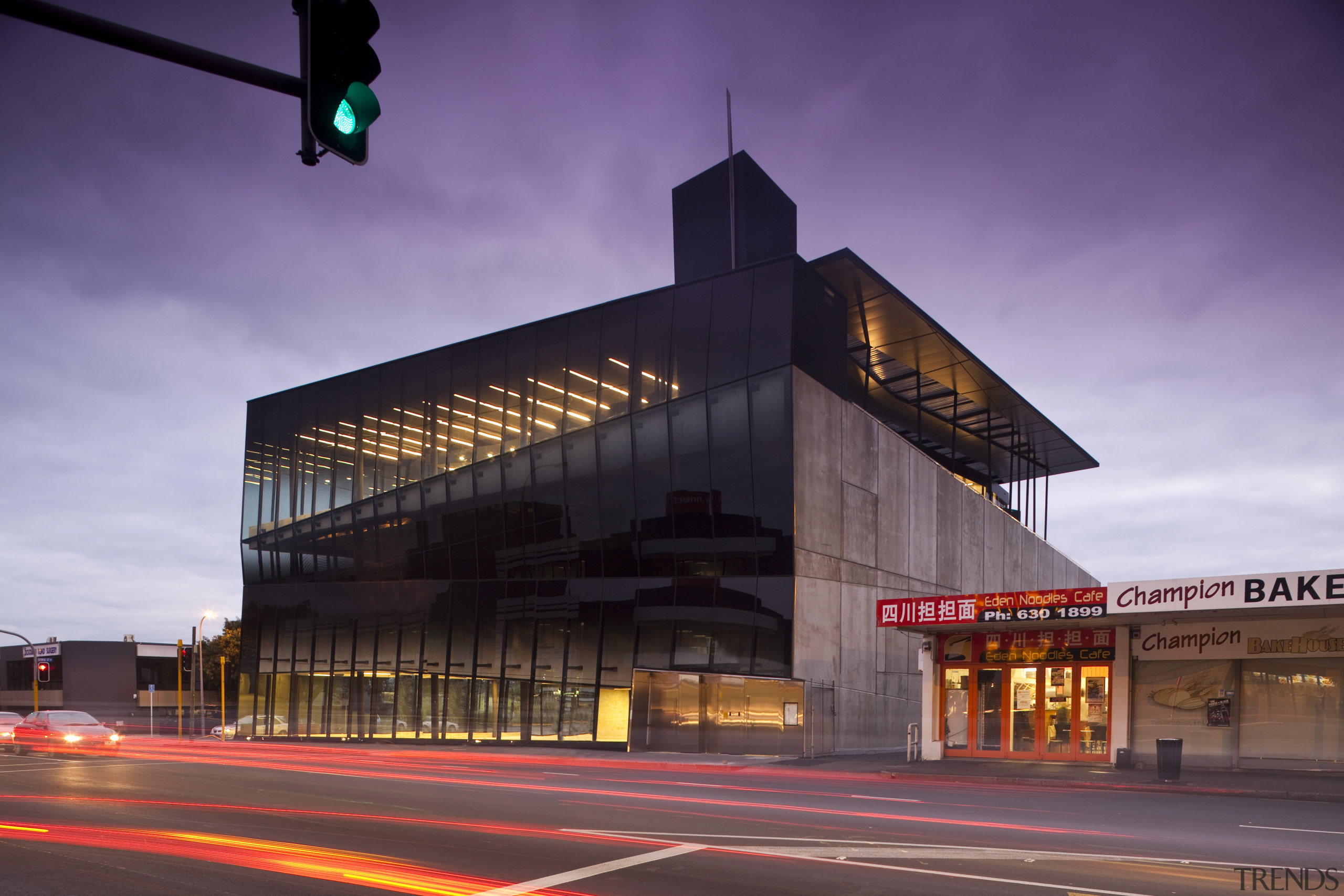 View of the Anvil Building, with angled custom architecture, building, city, downtown, evening, facade, infrastructure, landmark, metropolis, metropolitan area, night, sky, structure, urban area, purple