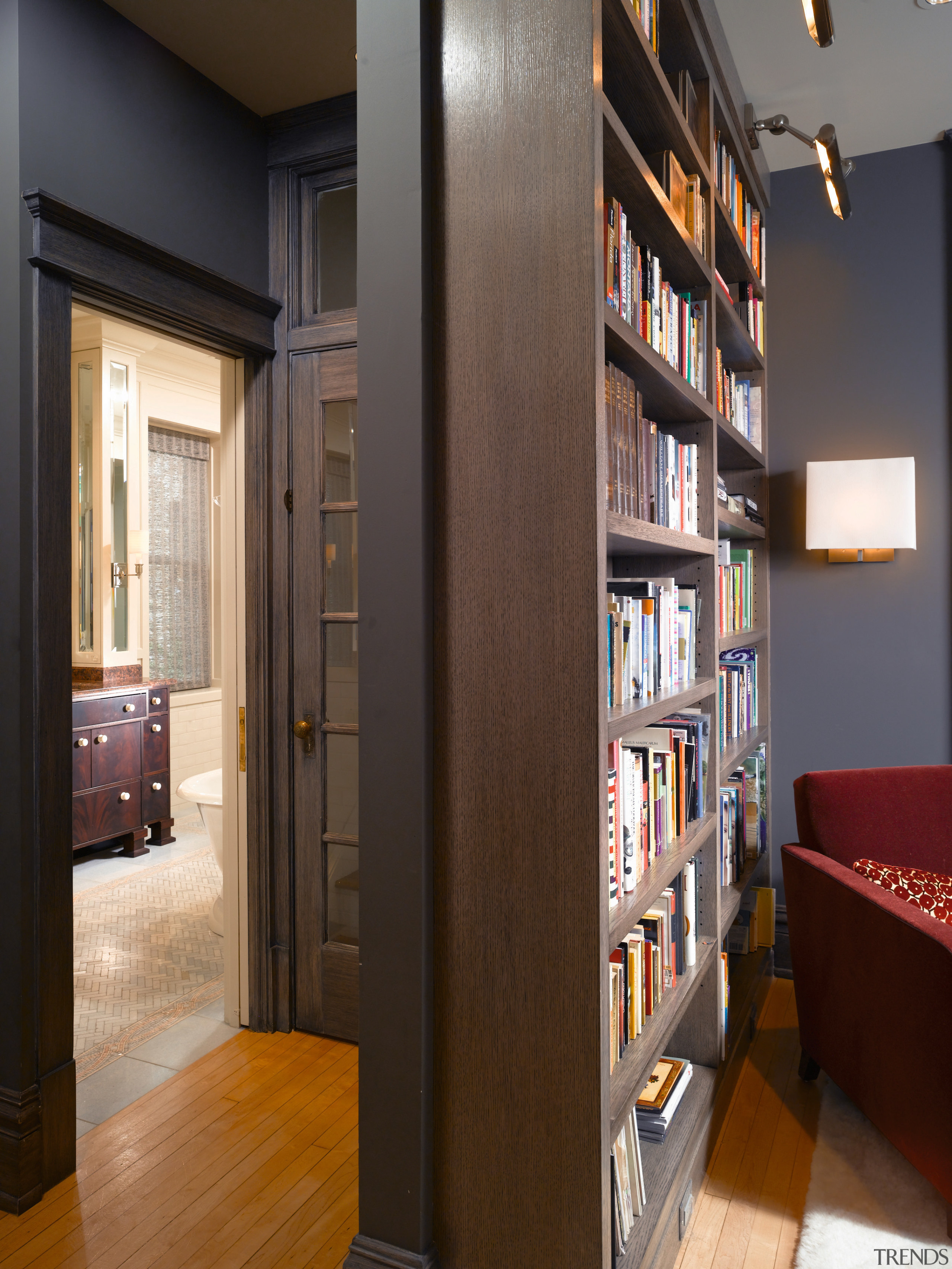 A view of the library which gives access bookcase, cabinetry, floor, flooring, furniture, interior design, library, shelf, shelving, brown