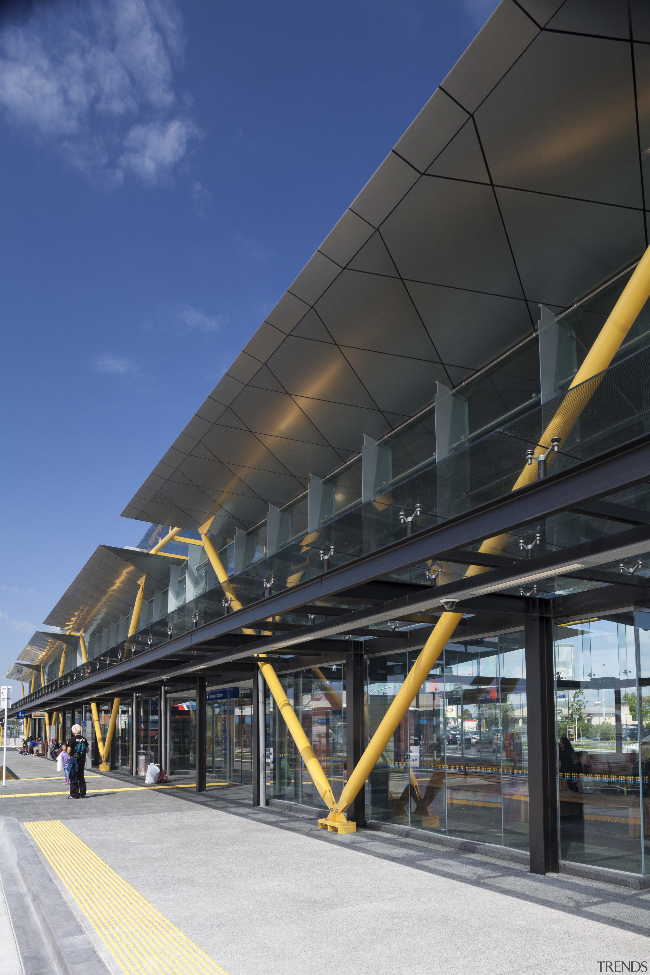 Railway stations, including New Lynn, have upgraded providing architecture, building, corporate headquarters, daytime, facade, fixed link, infrastructure, landmark, line, metropolis, metropolitan area, overpass, sky, skyway, structure, transport, urban area, black, blue