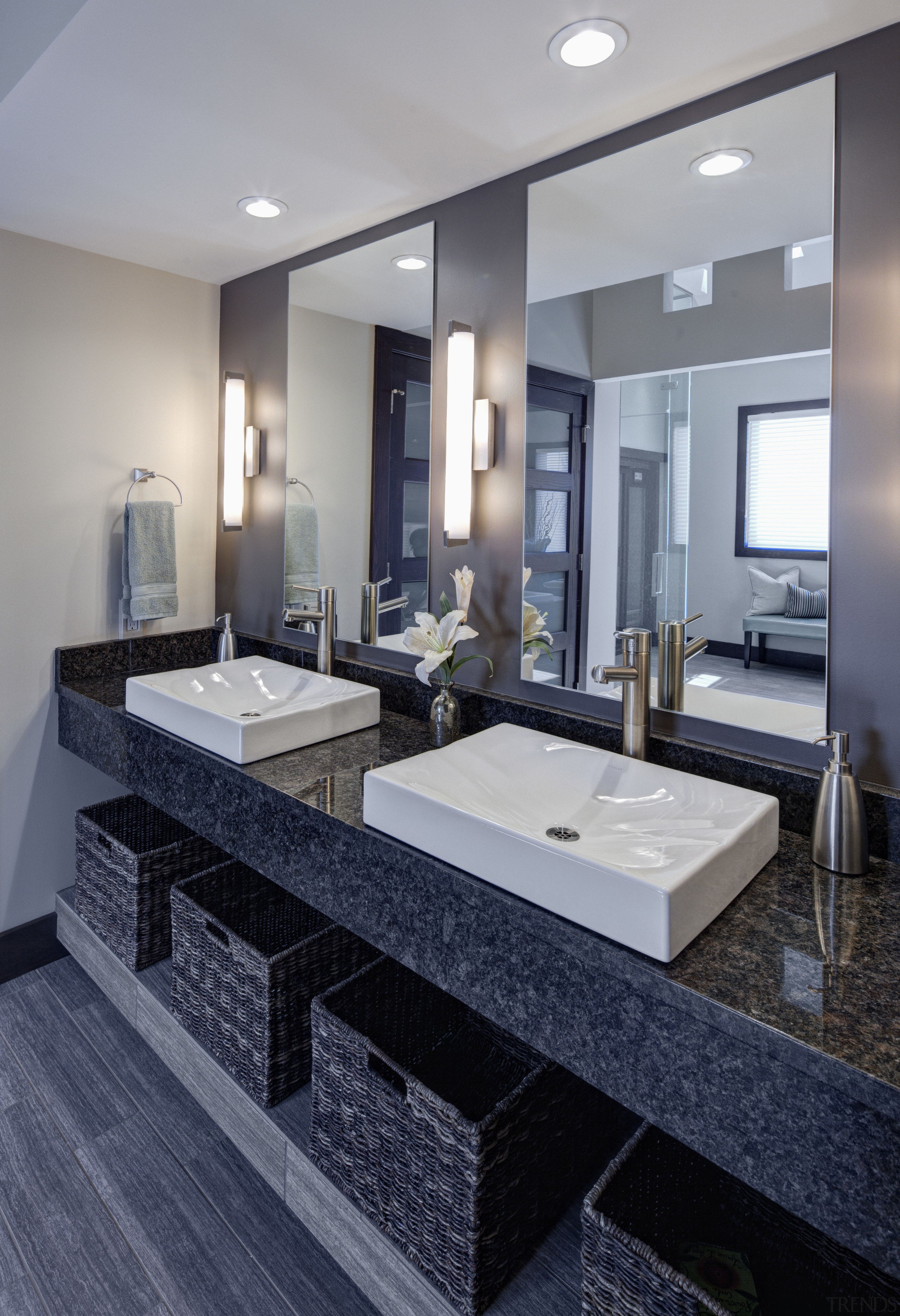 Large vanity mirrors reflect the view. The vanity bathroom, countertop, floor, flooring, interior design, room, sink, tile, gray, blue