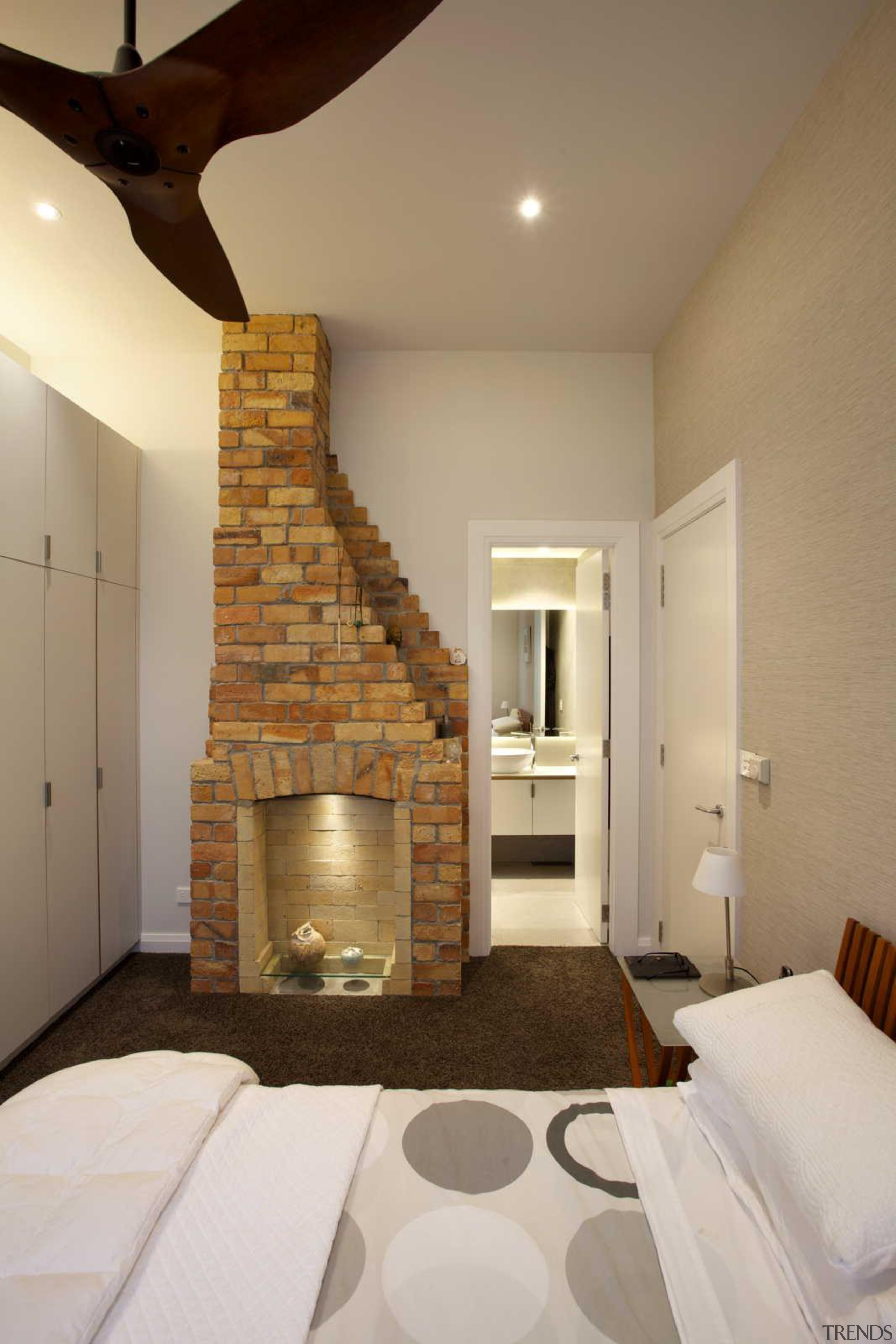 12.	Traditional meets modern in the bed and bathroom. bedroom, ceiling, estate, fireplace, floor, hearth, home, interior design, living room, property, real estate, room, wall, brown, gray