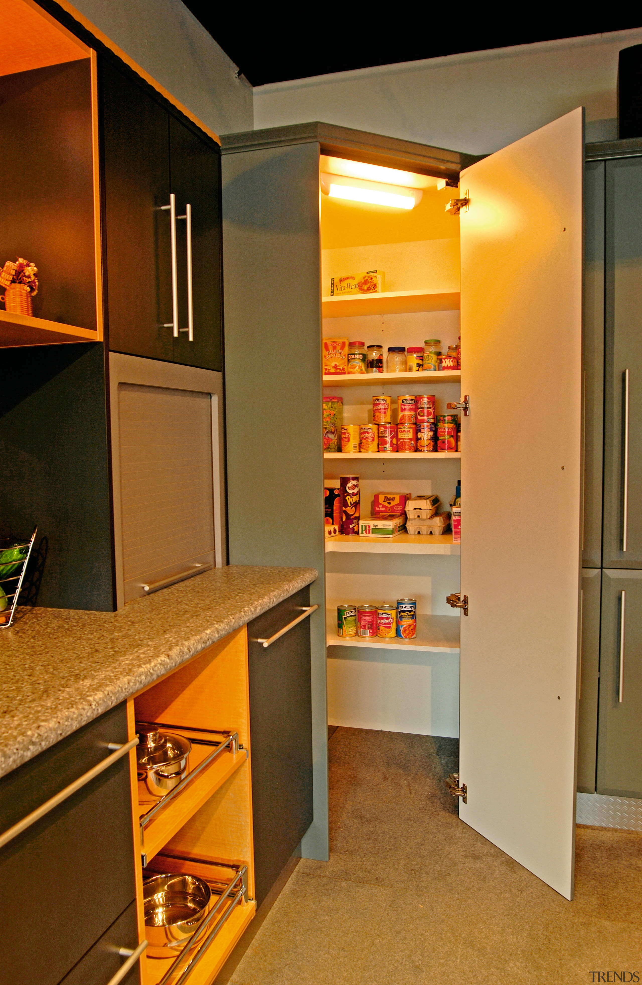 Showroom kitchen with grey benchtop, dark grey and cabinetry, closet, countertop, furniture, interior design, kitchen, room, shelf, shelving, brown, orange