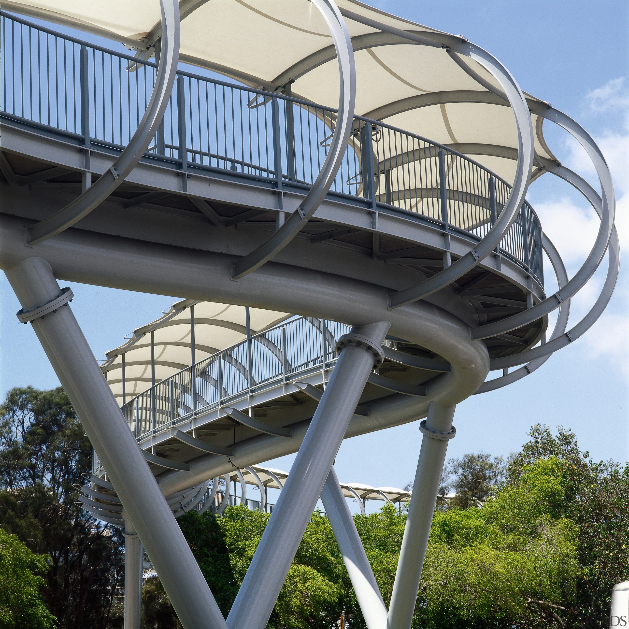 View of curved pedestrian foot bridge showing steel architecture, bridge, building, fixed link, landmark, sky, structure, tree, black