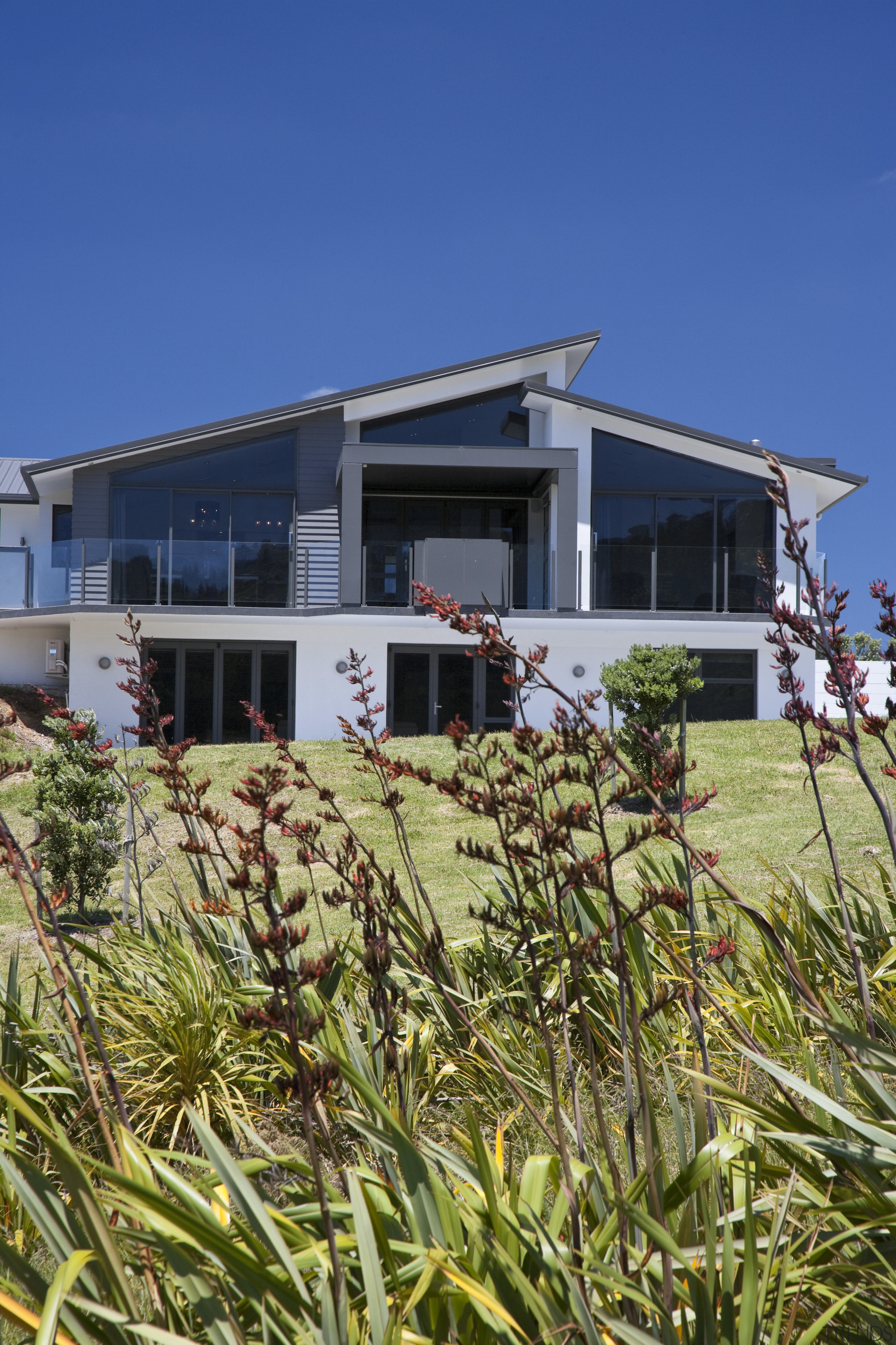 This home, by David Reid Homes Hauraki, features building, cottage, home, house, property, real estate, residential area, sky, blue