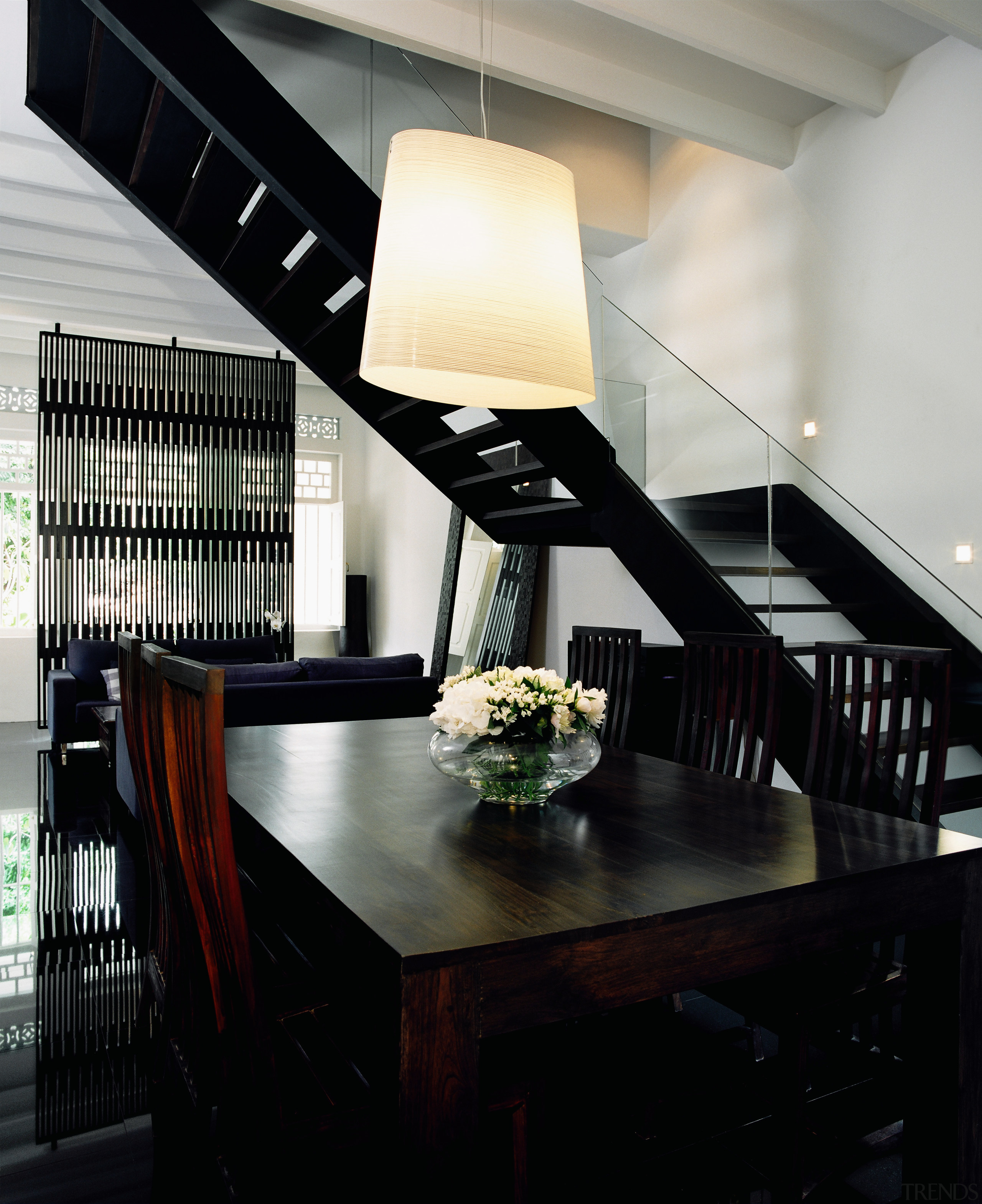 The architects chose a black-and-white theme to unify ceiling, dining room, furniture, interior design, light fixture, lighting, table, black, gray