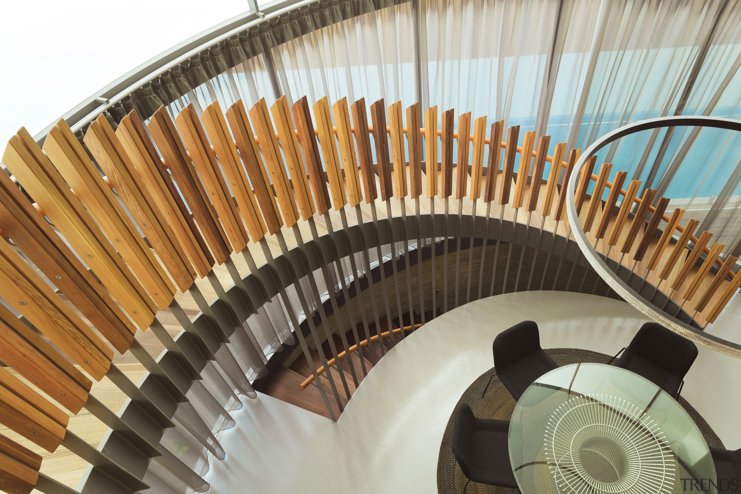 A spiral staircase looks down on the dining stairs, brown