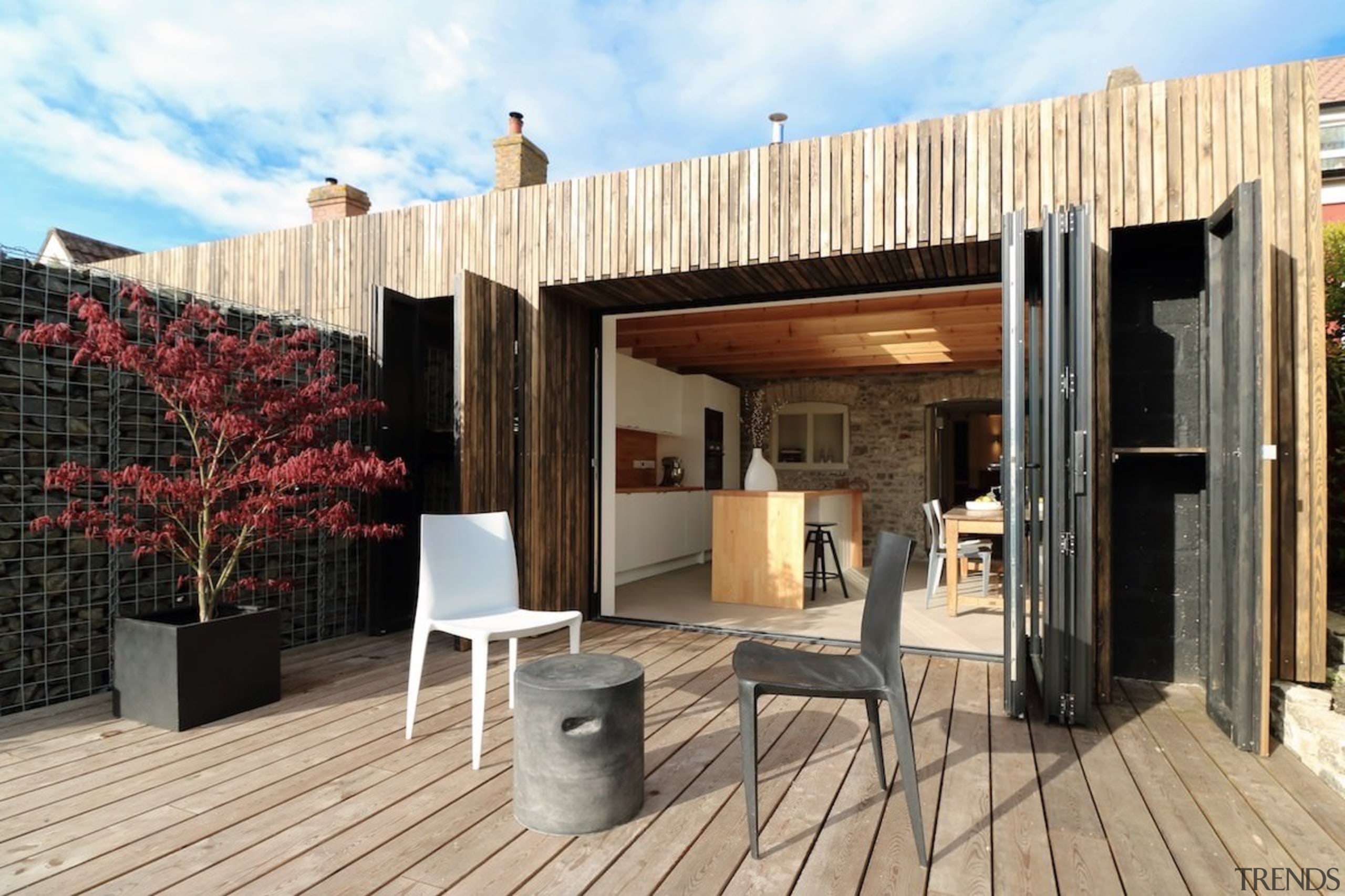 You can see the older home within - architecture, deck, facade, house, outdoor structure, property, real estate, orange