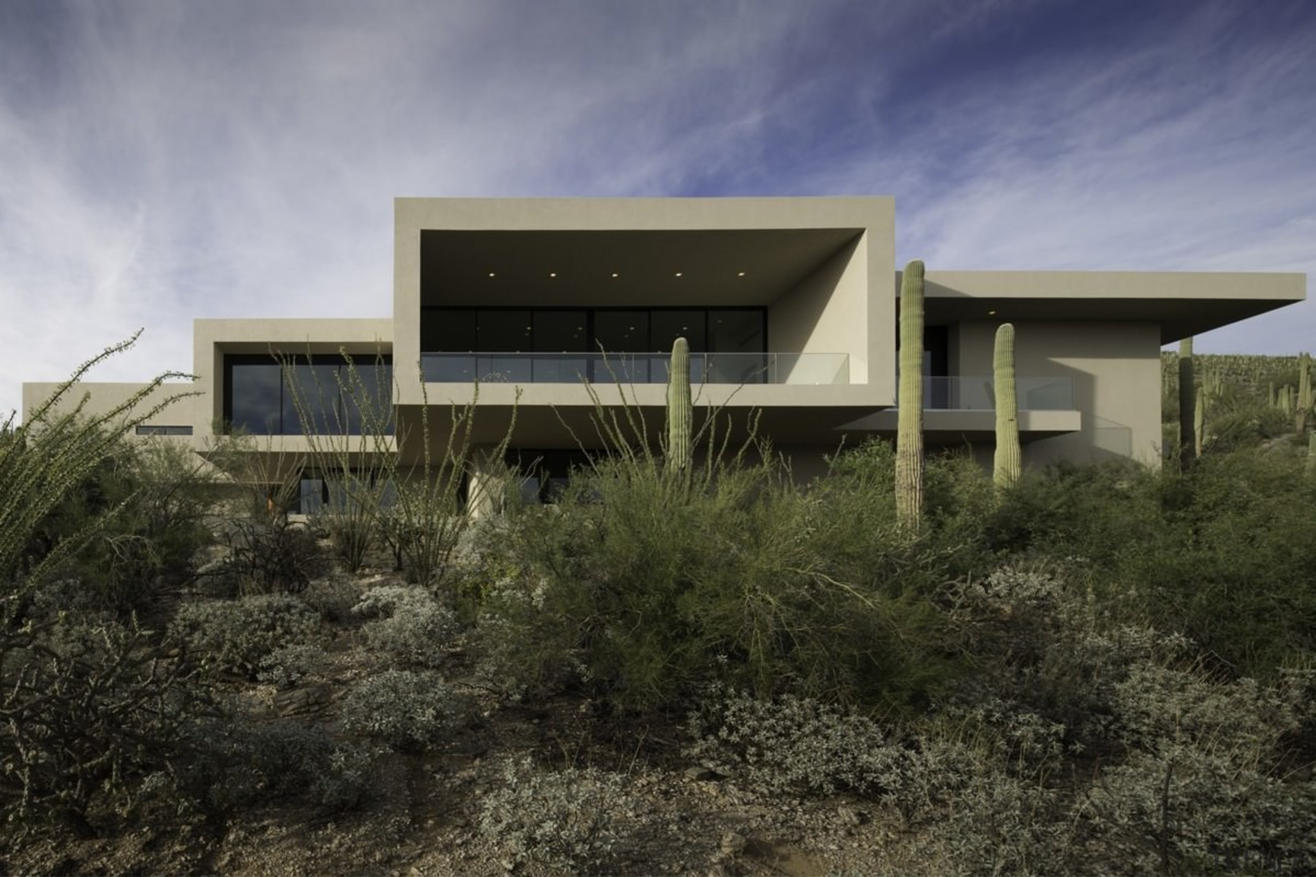 From the desert, the home almost seems to architecture, building, elevation, home, house, landscape, property, real estate, sky, black, gray