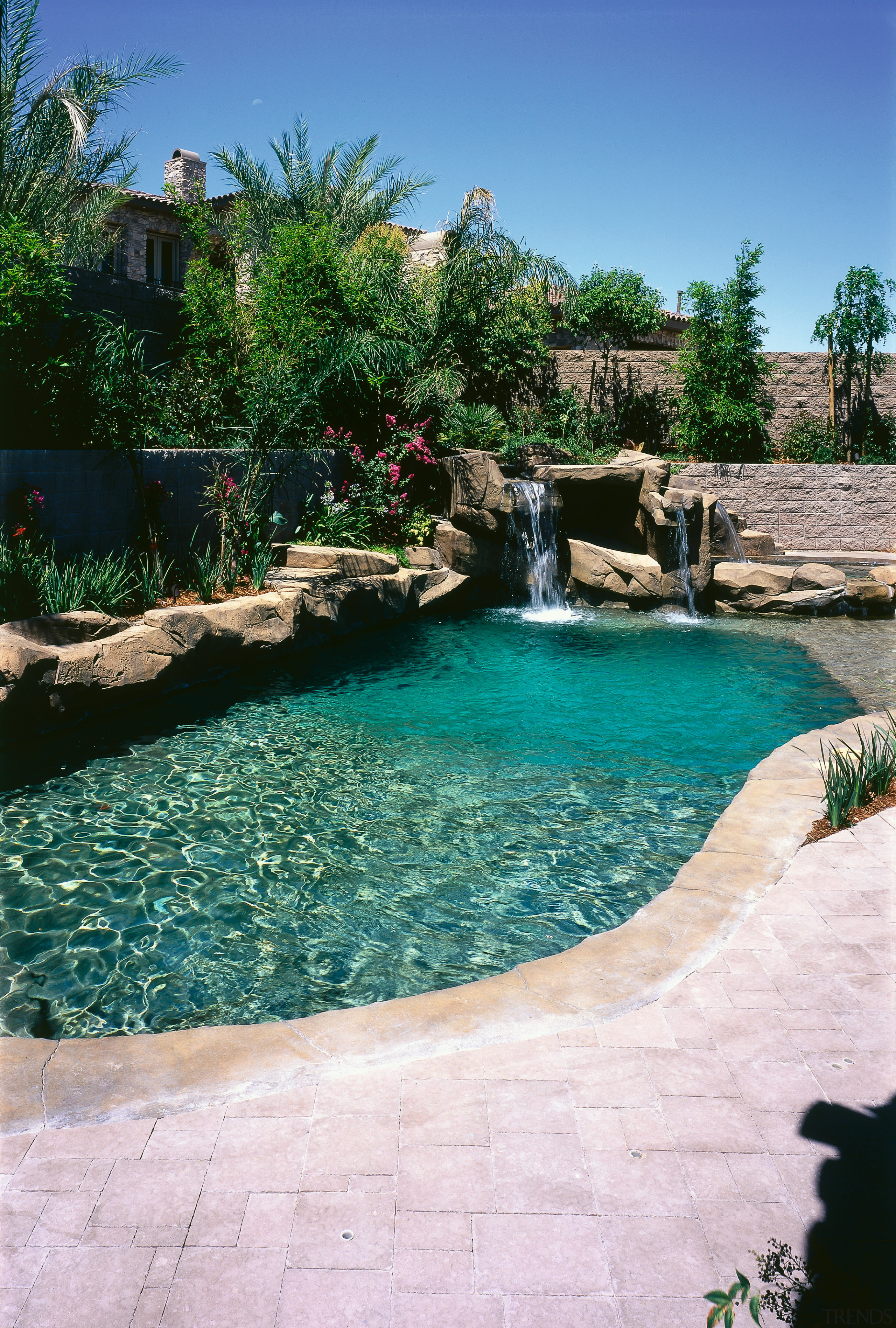 view of the exotic pool area featuring waterfall, arecales, backyard, estate, landscape, landscaping, leisure, outdoor structure, plant, pond, resort, swimming pool, water, water feature, water resources, white