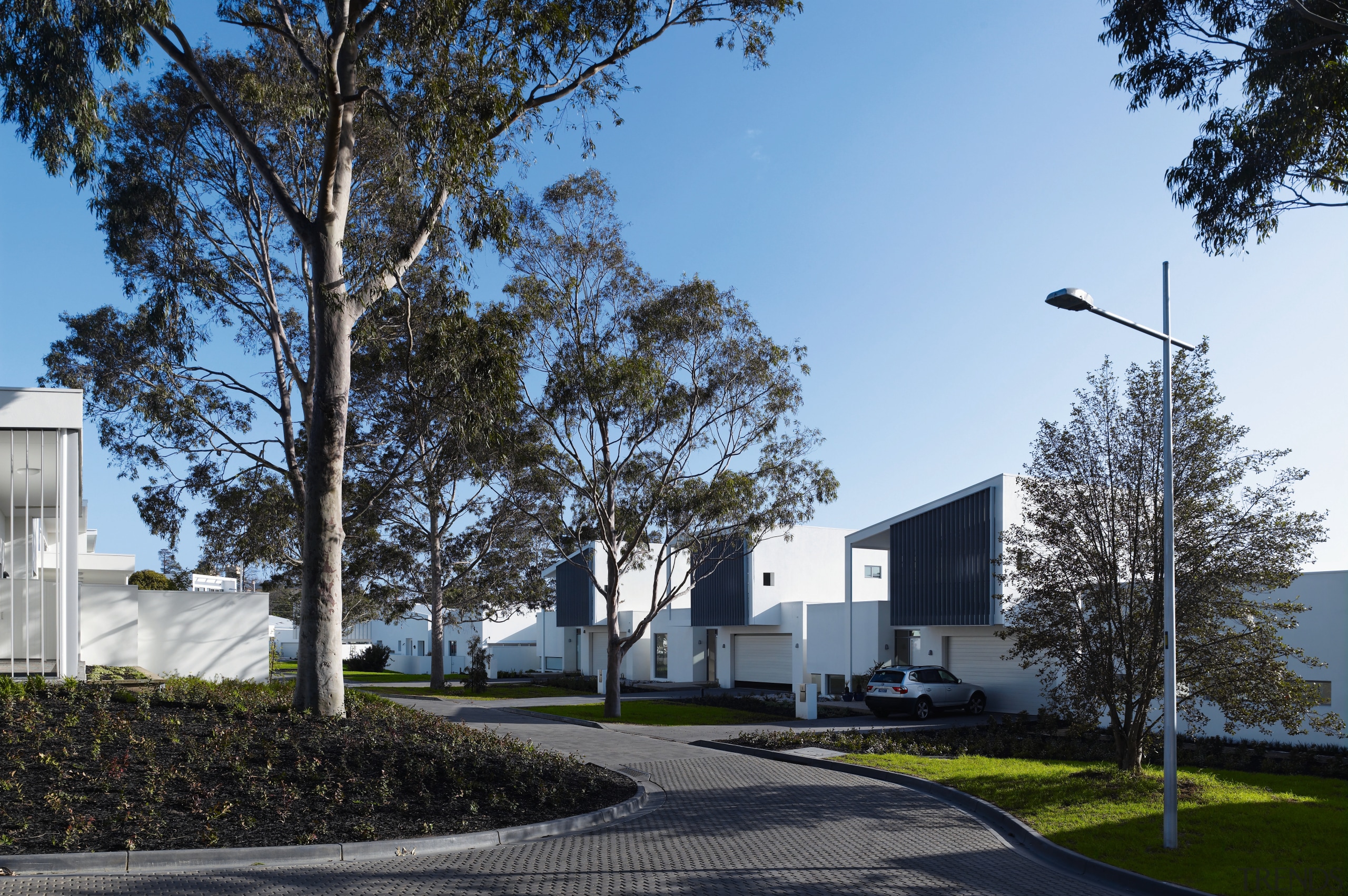View of the exterior of the town houses architecture, building, corporate headquarters, daytime, estate, facade, home, house, neighbourhood, property, real estate, residential area, sky, tree, black