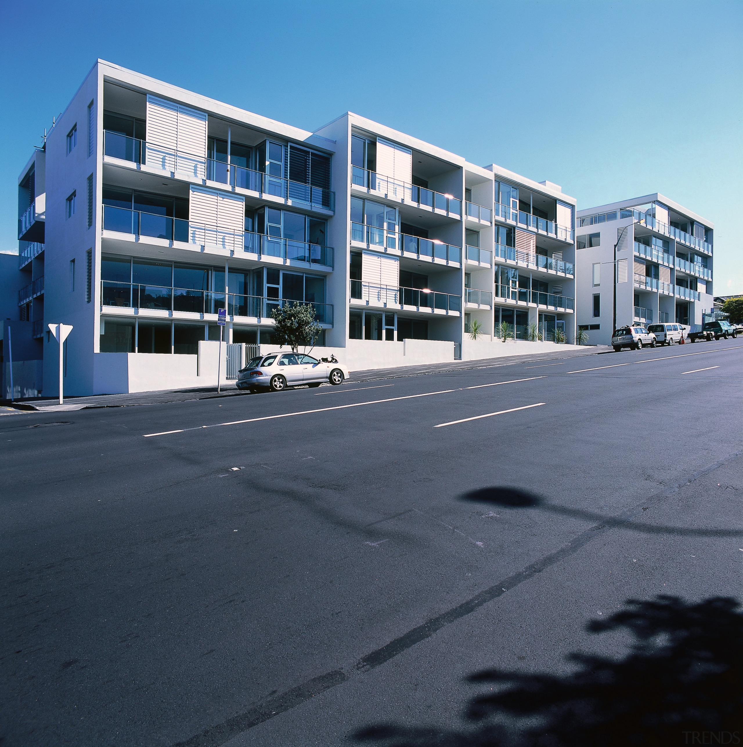 An exterior view of some apartments. - An apartment, architecture, building, commercial building, condominium, corporate headquarters, estate, facade, family car, home, house, metropolitan area, mixed use, neighbourhood, property, real estate, residential area, sky, suburb, window, black