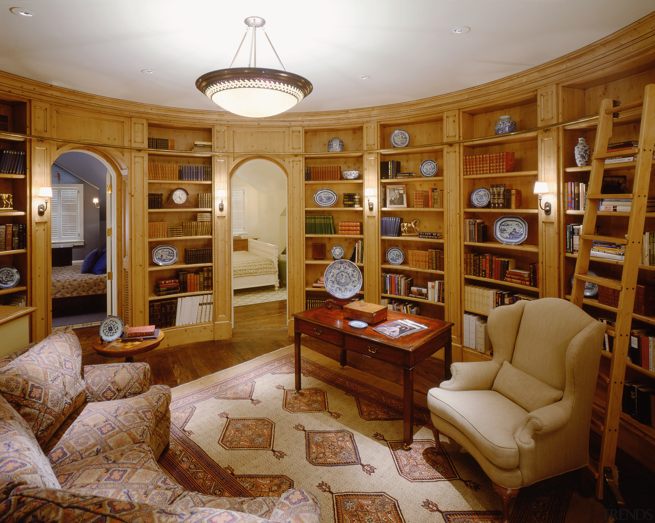 A view of the library featuring timber shelving, bookcase, ceiling, estate, furniture, home, interior design, library, living room, property, real estate, brown