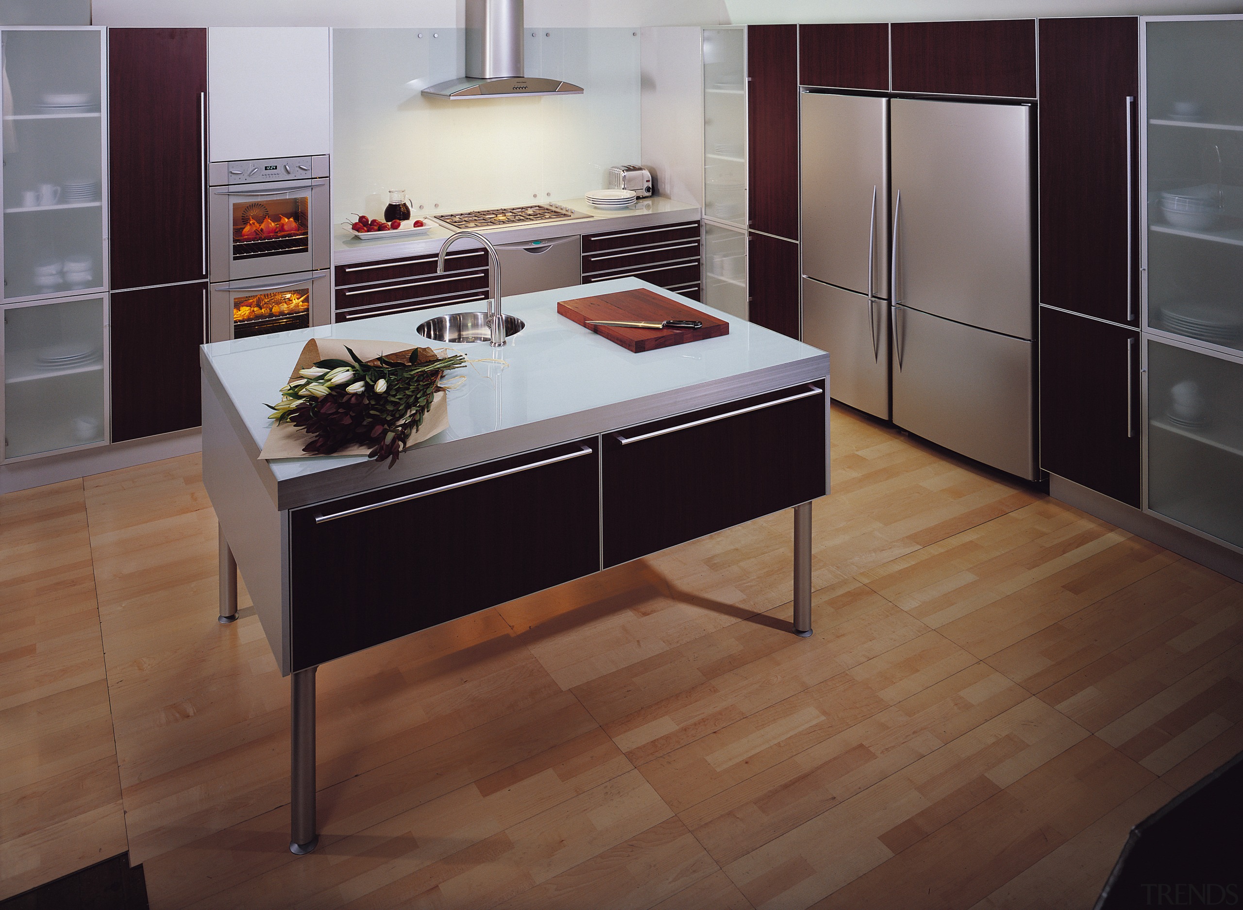 A kitchen featuring an island with an Iridium cabinetry, countertop, cuisine classique, floor, flooring, furniture, hardwood, interior design, kitchen, laminate flooring, tile, wood, wood flooring, brown, gray, black