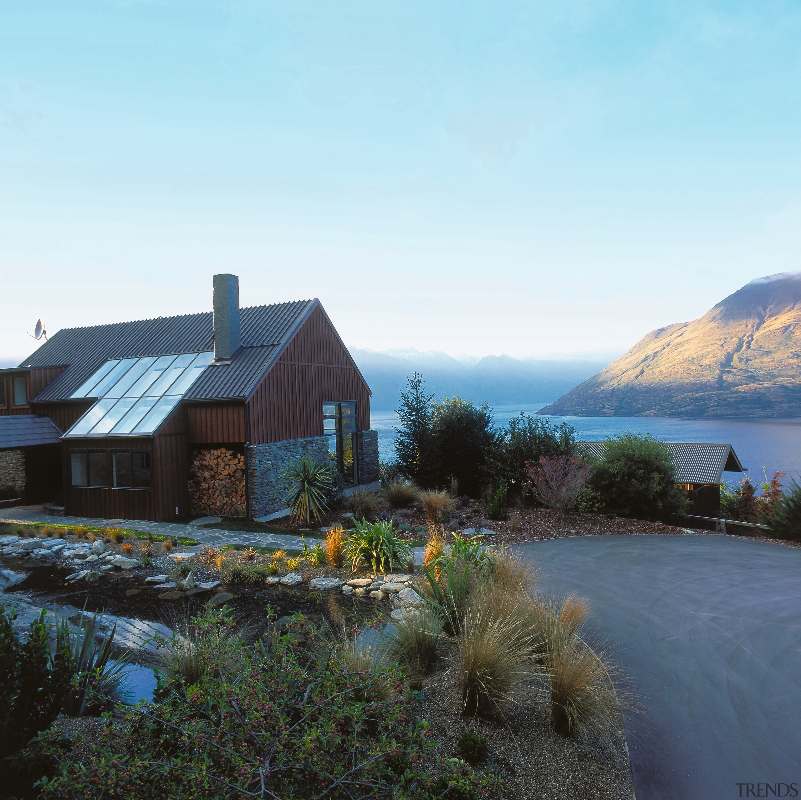 view of azur lodge featuring local shcist and cloud, cottage, estate, fell, fjord, highland, home, house, lake, landscape, loch, morning, mountain, property, real estate, reflection, roof, rural area, sky, tree, water, wilderness, winter, white, black