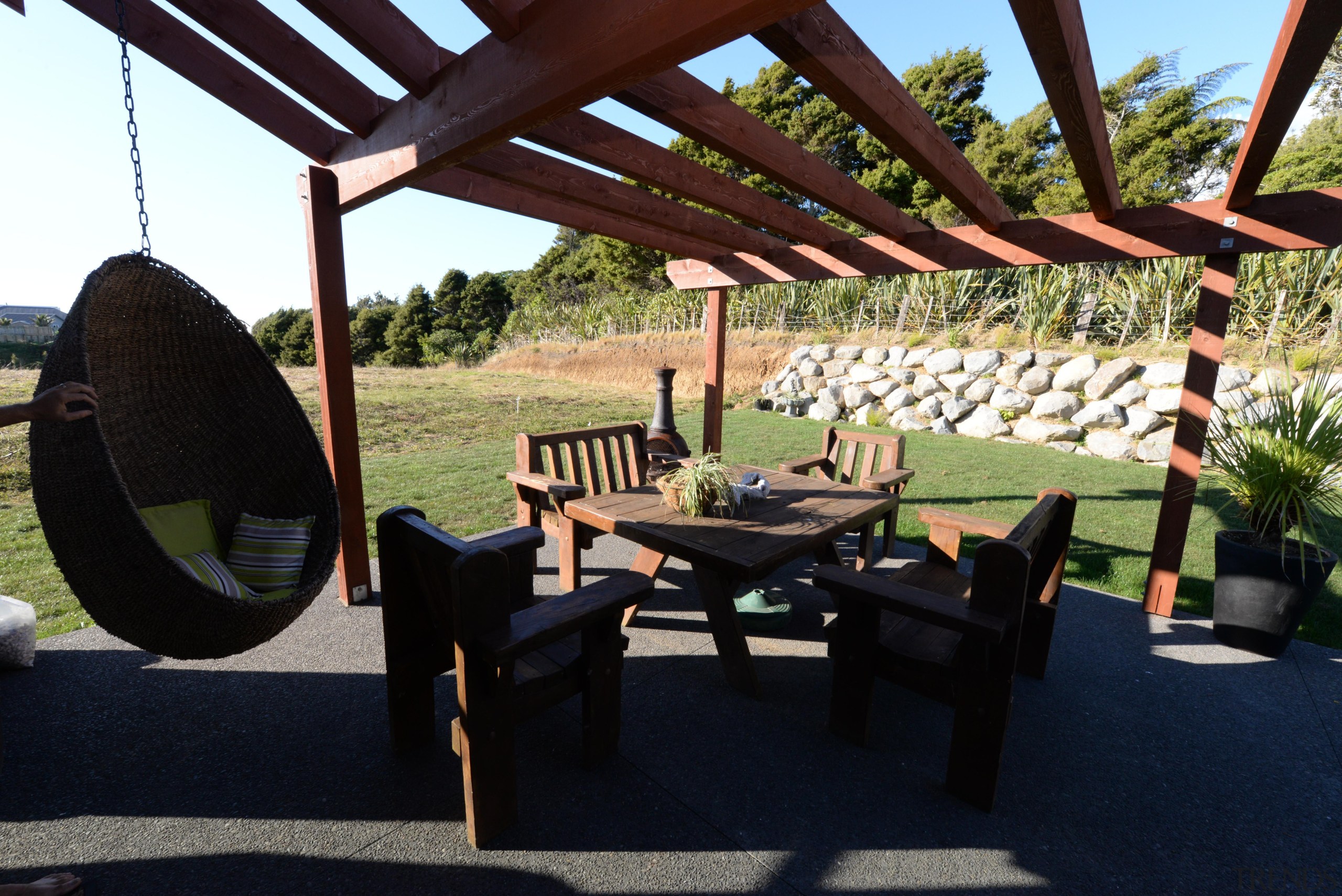 A patio with timber based decor at a furniture, outdoor structure, property, table, black